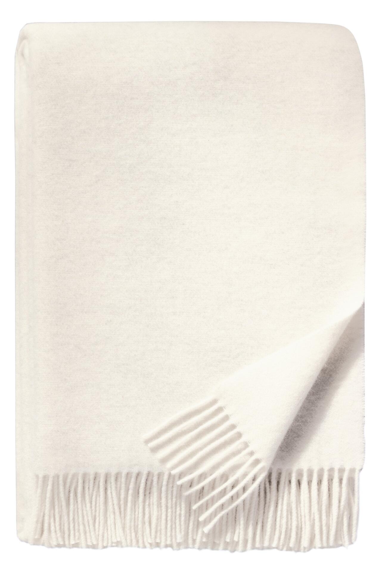 Flauschige cremeweiße Plaid-Decke mit dichtem Fransenmuster und gewellter Textur.