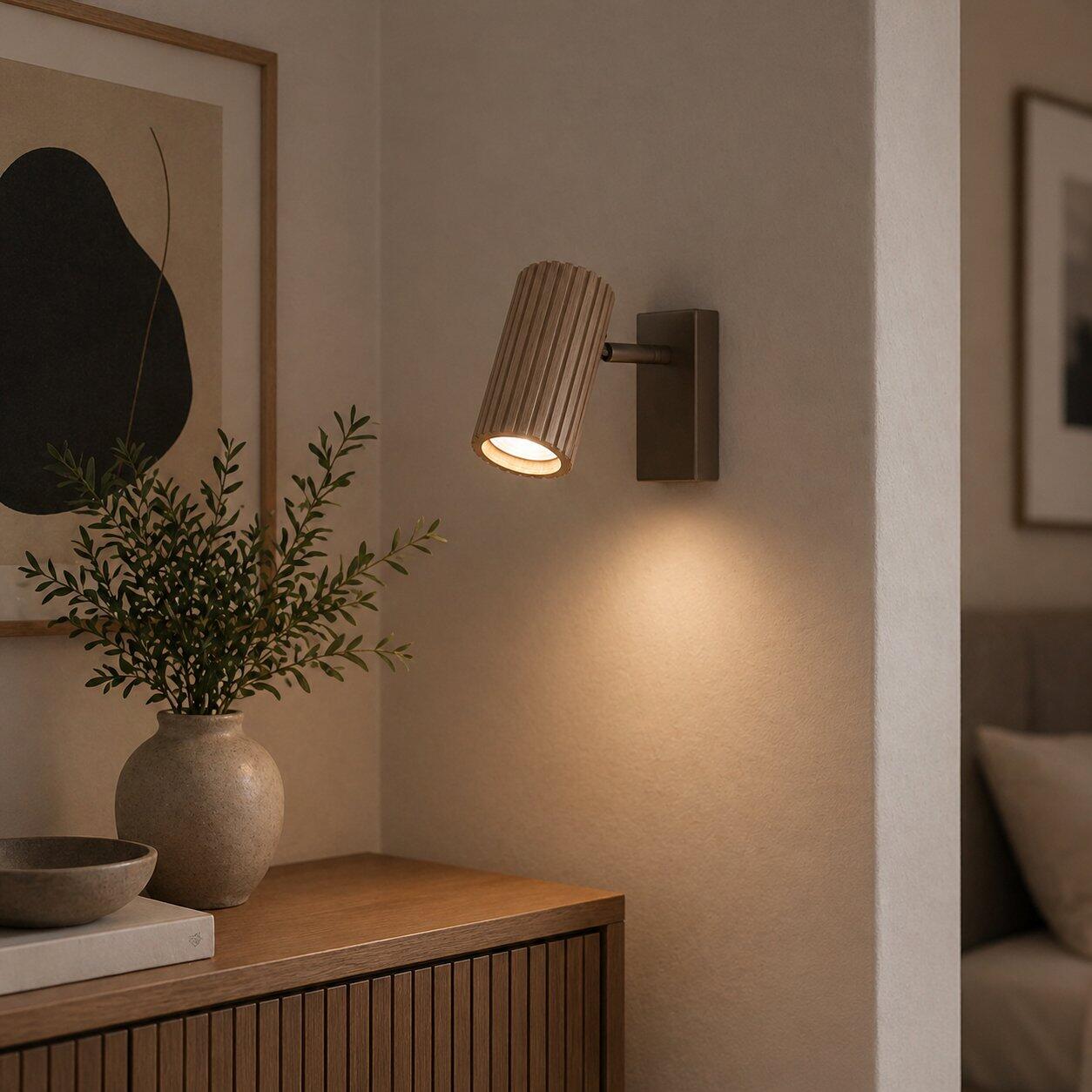 Lakewood Wandleuchte mit schwenkbarem Lampenkopf, die von unten und leicht seitlich beleuchtet wird und eine flexible Lichtausrichtung ermöglicht.