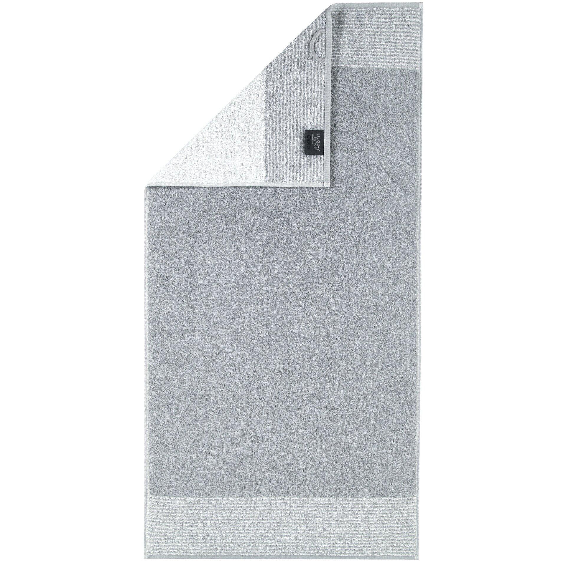 Duschtuch Two-Tone von CAWÖ, hellgrau und flauschig, mit kleinem schwarzem Etikett im oberen linken Bereich.