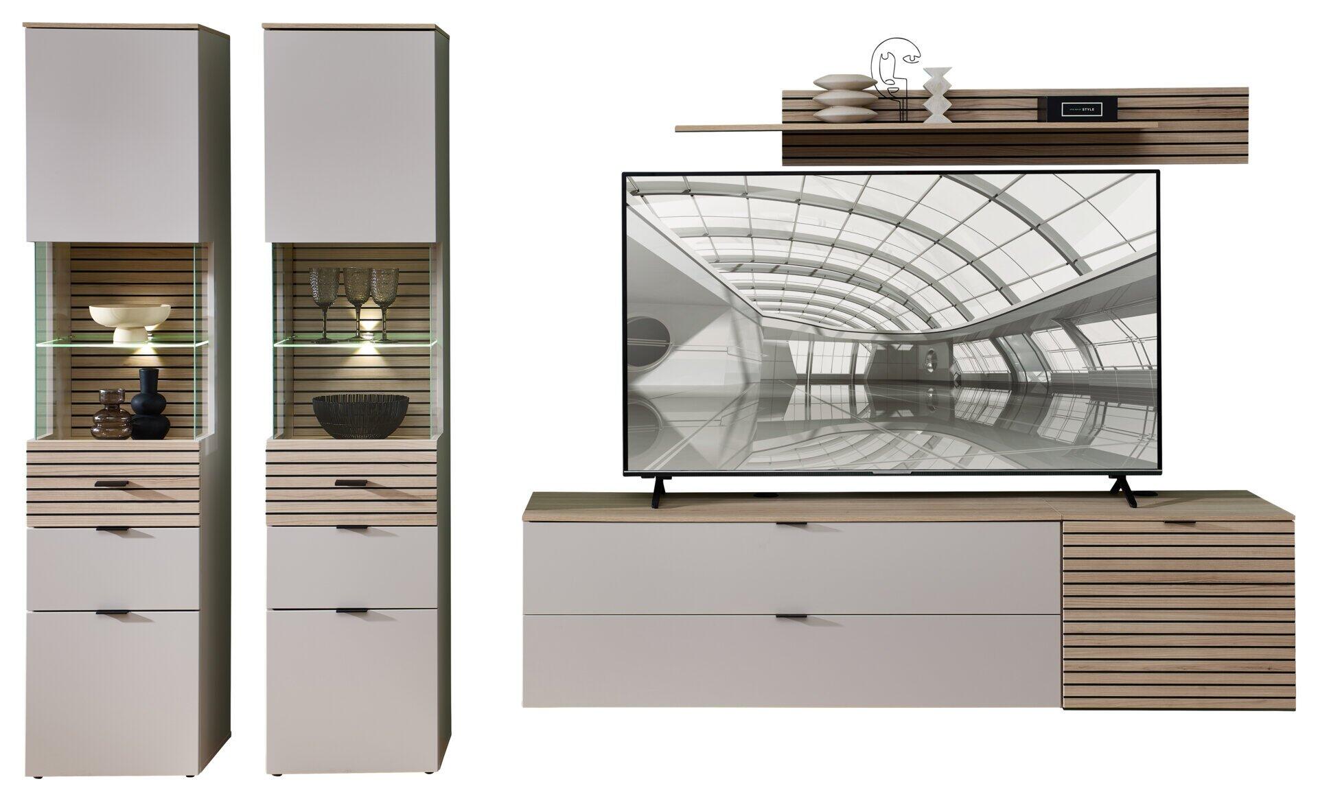 TV-/Wohnlösung Ina aus Riva Eiche und Kaschmir MDF mit LED-Beleuchtung und Vitrinenschrank mit Glastüren, die Dekorationsgegenstände zeigen.