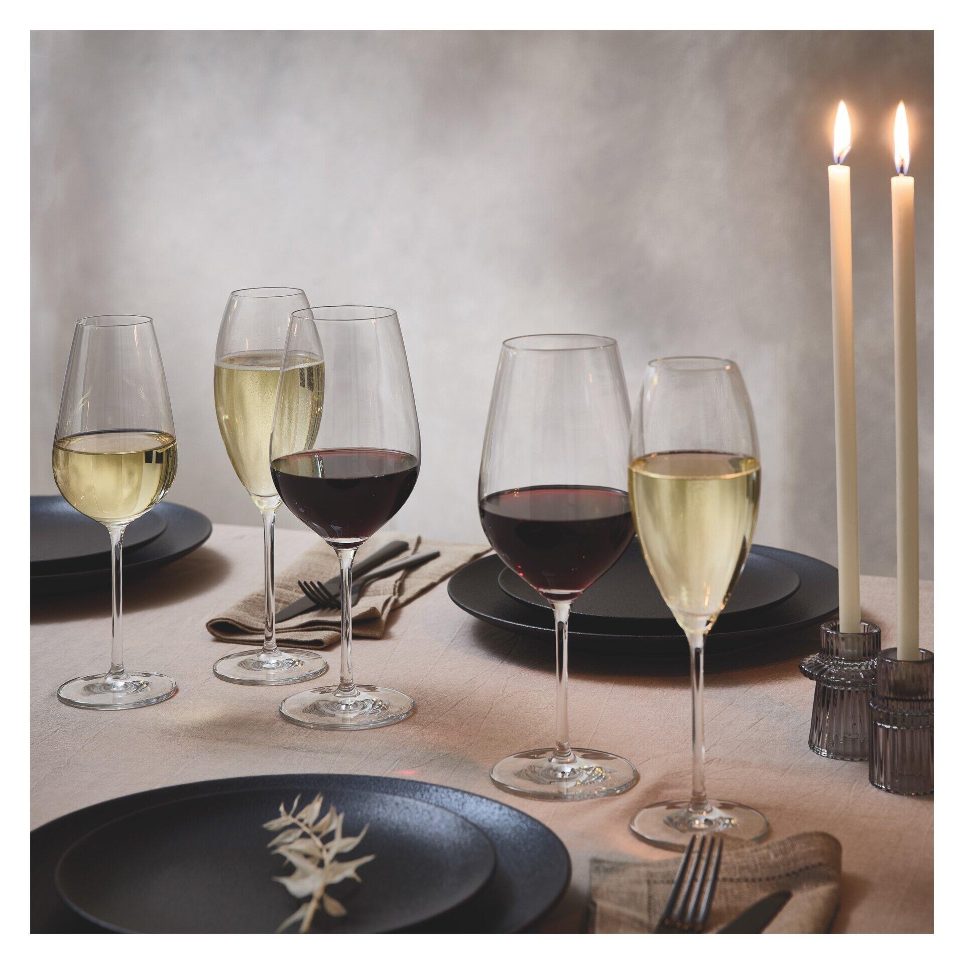 Rotweinglas-Set: Detailaufnahme von vier eleganten Weingläsern, darunter zwei Rotweingläser, auf einer stilvoll gedeckten Tafel mit Leinentuch und Besteck.