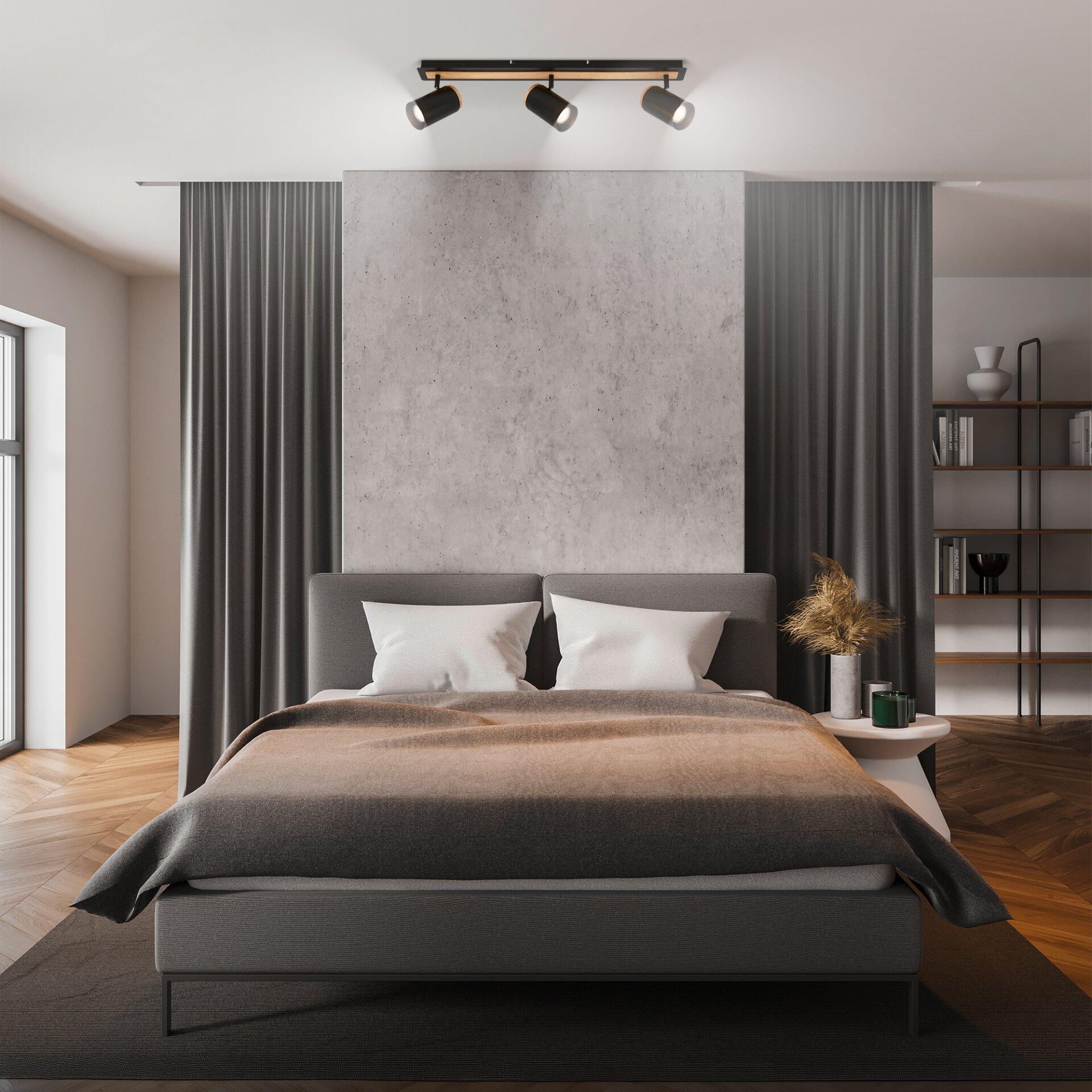 Moderne Duta Spot Schlafzimmerbeleuchtung mit drei GU10-Leuchten über einem Bett mit grauem Bezug und hoch gepolstertem Rücken.