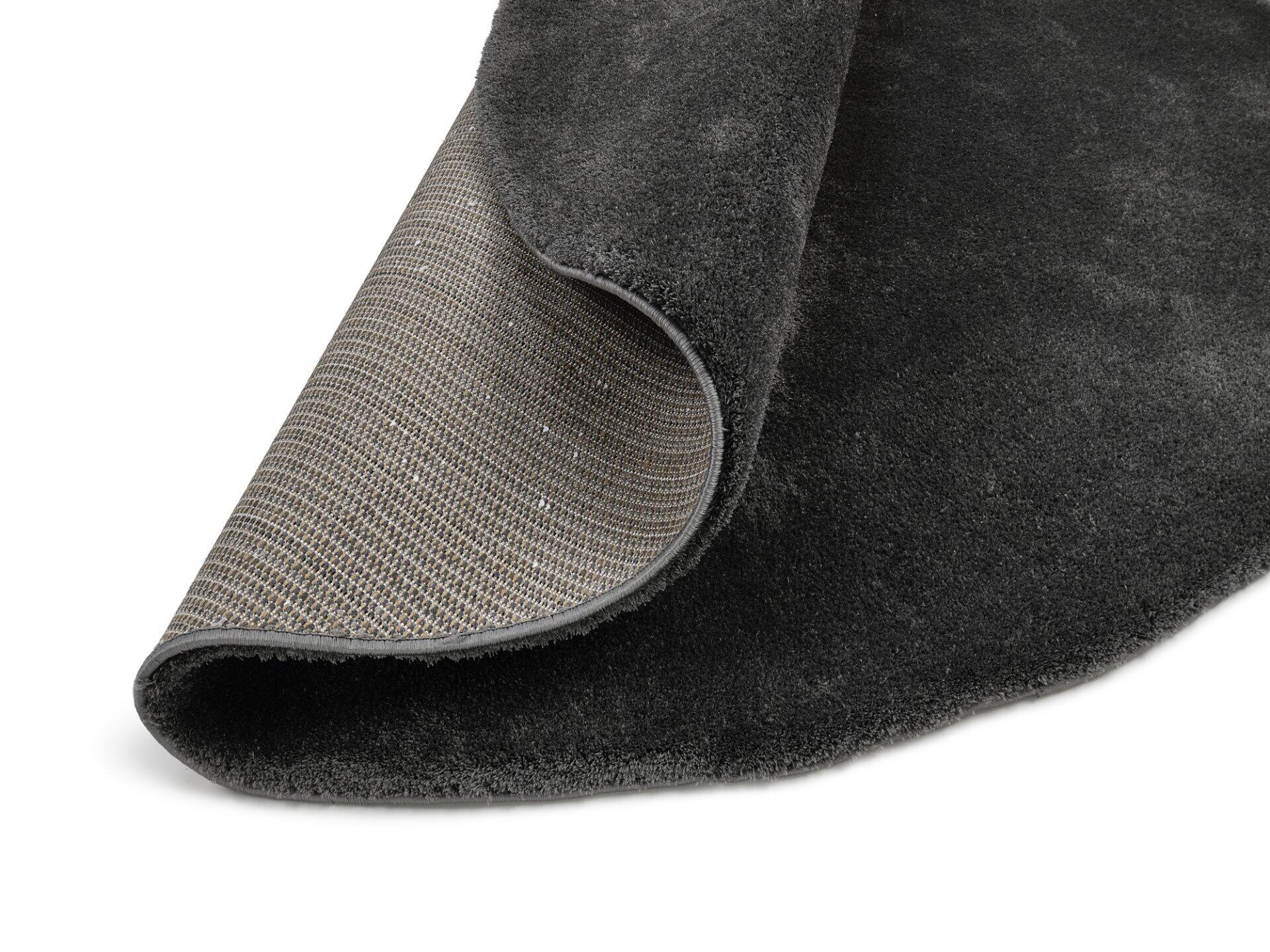 Maschinenwebteppich Mardin: Detailaufnahme des Hochflor-Teppichs mit dunklem, flauschigem Flor und rutschfester, gefalteter Unterseite.