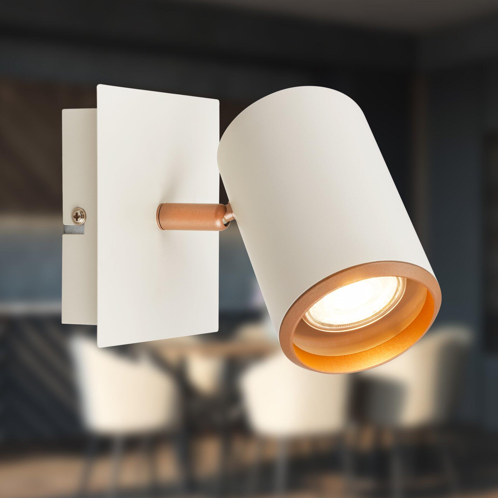 Moderne Wandleuchte Spot, Era, mit rechteckigem Wandhalter und zylindrischem Lampenkopf, umgeben von einem goldenfarbenen Ring, zeigt im Detailbild den eleganten und minimalistischen Look.