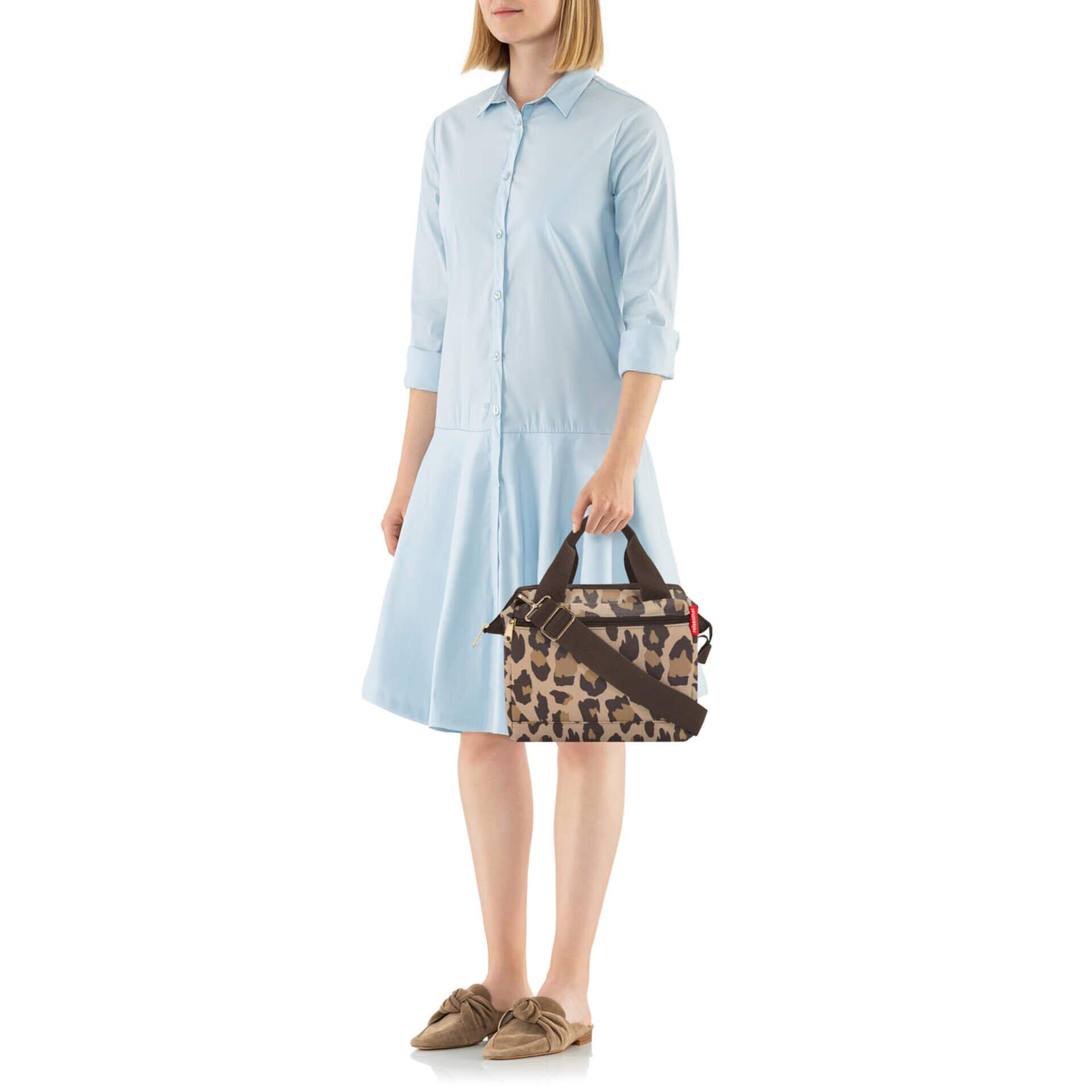 Frau trägt Allrounder Cross Handtasche mit Leopardenmuster, verstellbarem Schultergurt und kurzen Tragegriffen.