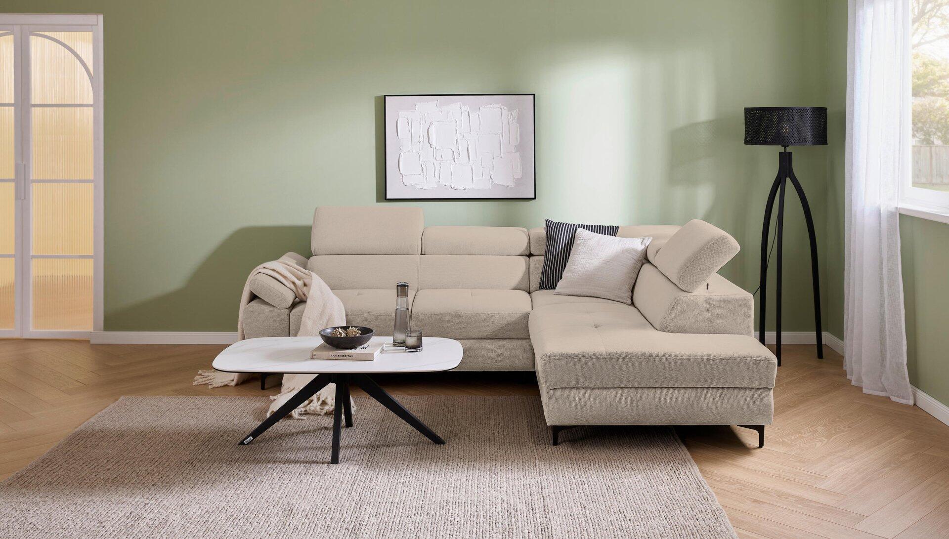 Ecksofa Combo in Beige mit abklappbarer Kopfstütze, verstellbaren Arm- und Kopfteilen und Winkelfüßen, fotografiert aus erhöhter Perspektive, um die Form und Struktur hervorzuheben.