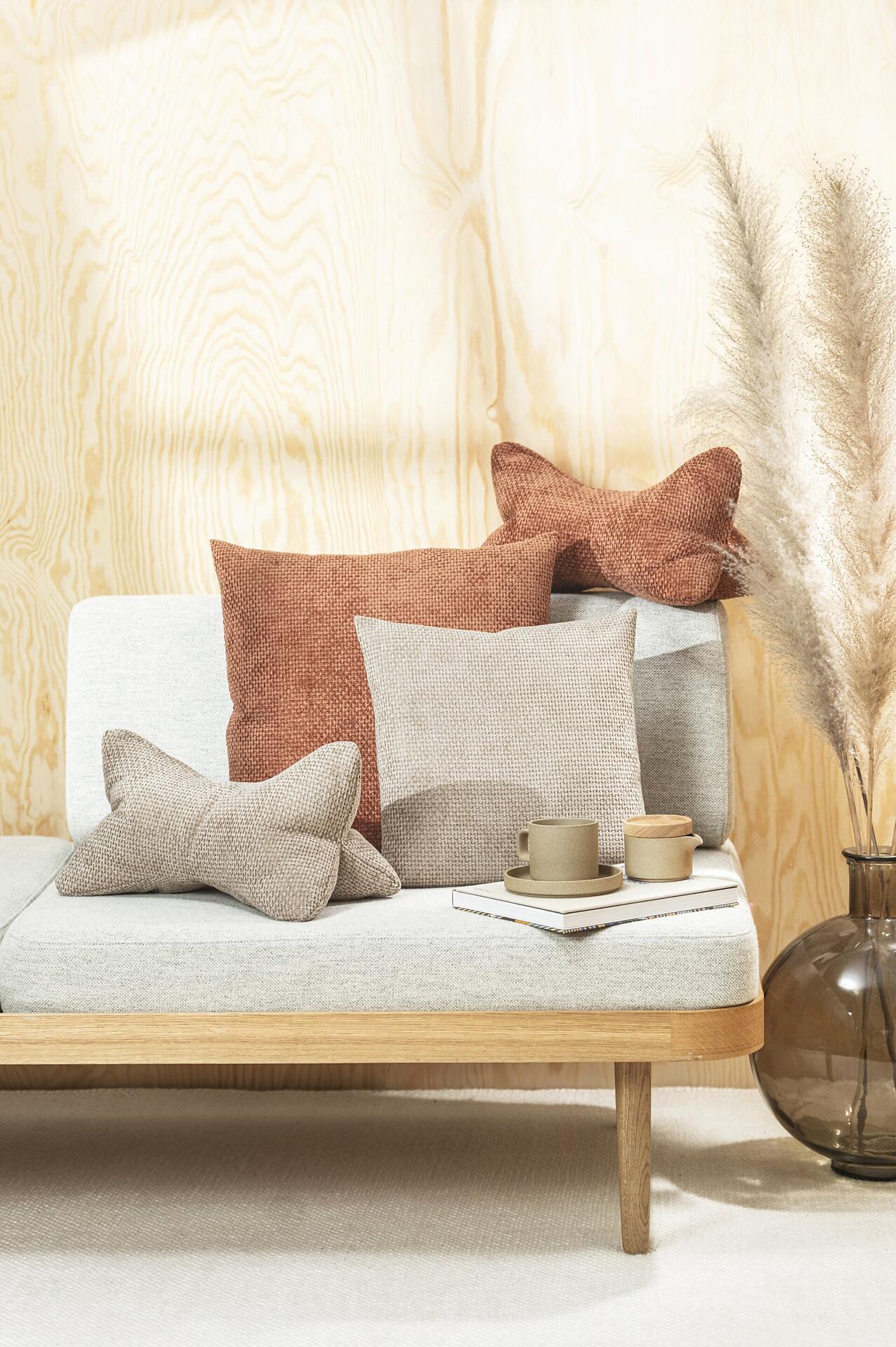 Leseknochen Arlo Sofa im hellgrauen Chenille-Design mit dekorativen Kissen, Büchern und einer Tasse, dargestellt aus erhöhter Perspektive für eine gemütliche Wohnatmosphäre.