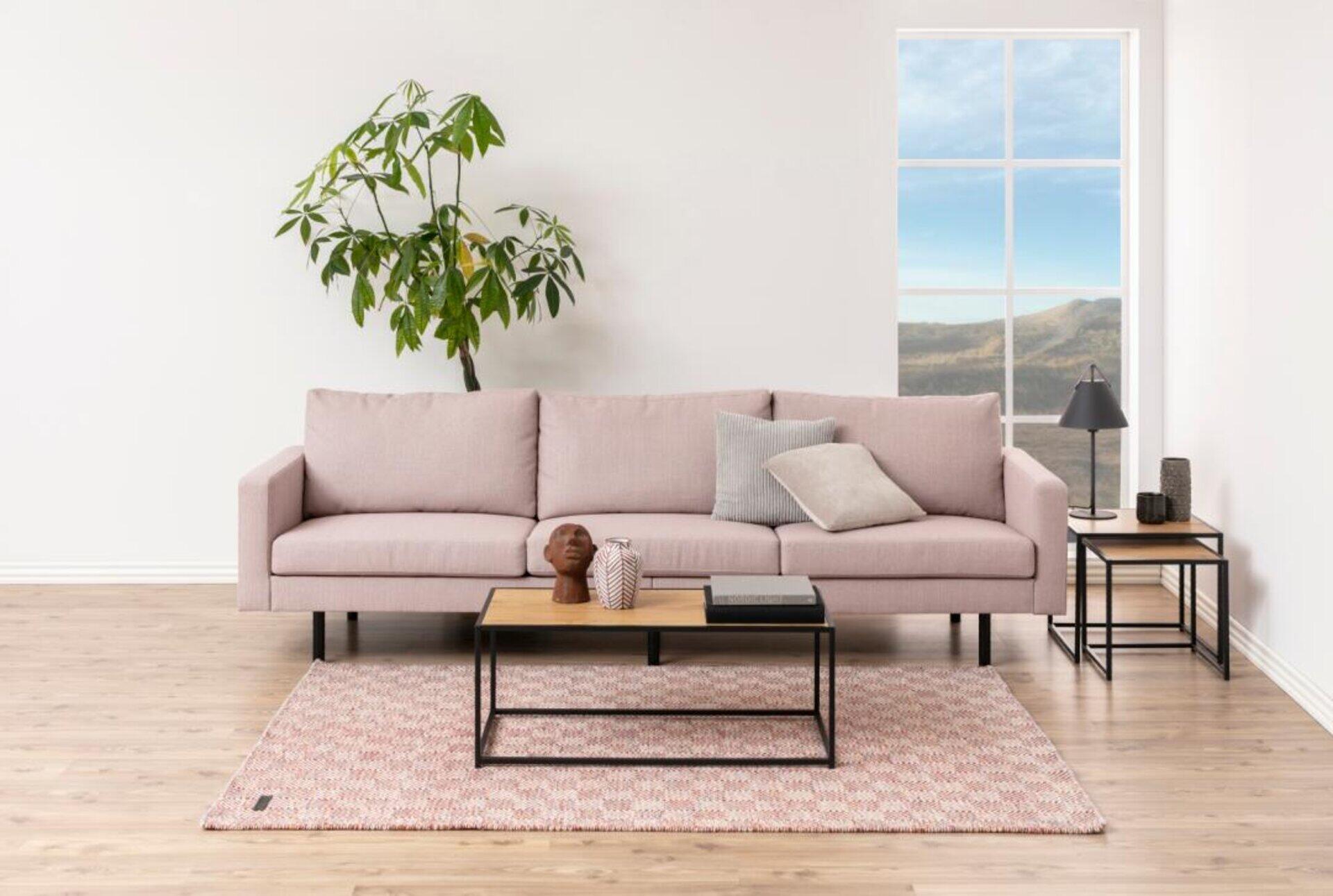 Couchtisch Seaford mit Holzplatte und schwarzen Metallbeinen in einer gemütlichen Wohnszene, frontal und leicht unterhalb aufgenommen.