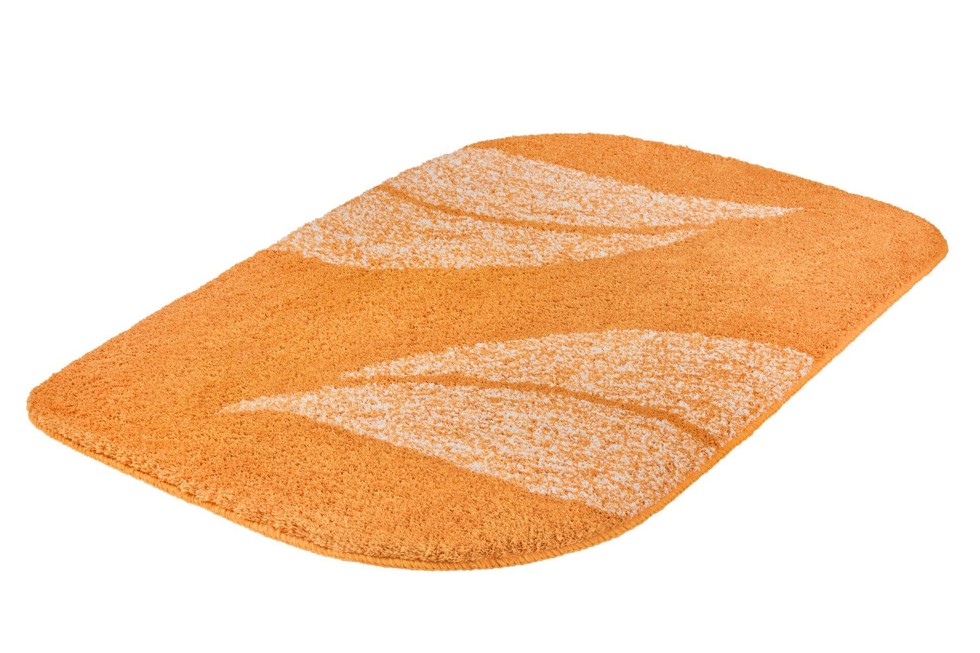 Badteppich Greta in Safran mit dynamischem, weißem Wellenmuster und flauschiger Oberfläche.
