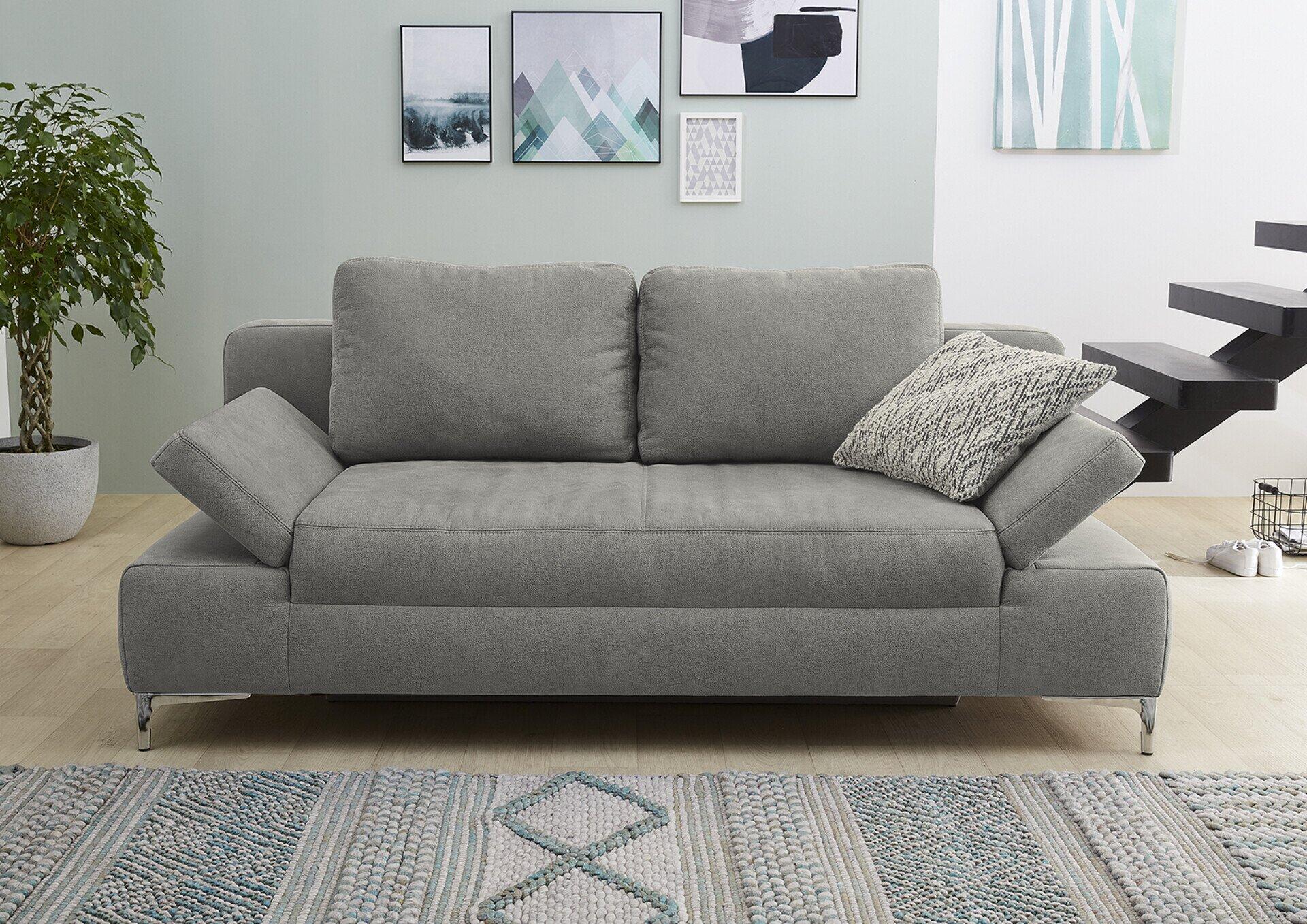 Graues Schlafsofa Jano mit breiten, leicht gebogenen Armlehnen und mehreren Rückenkissen, auf silberfarbenen Füßen, frontal abgebildet.