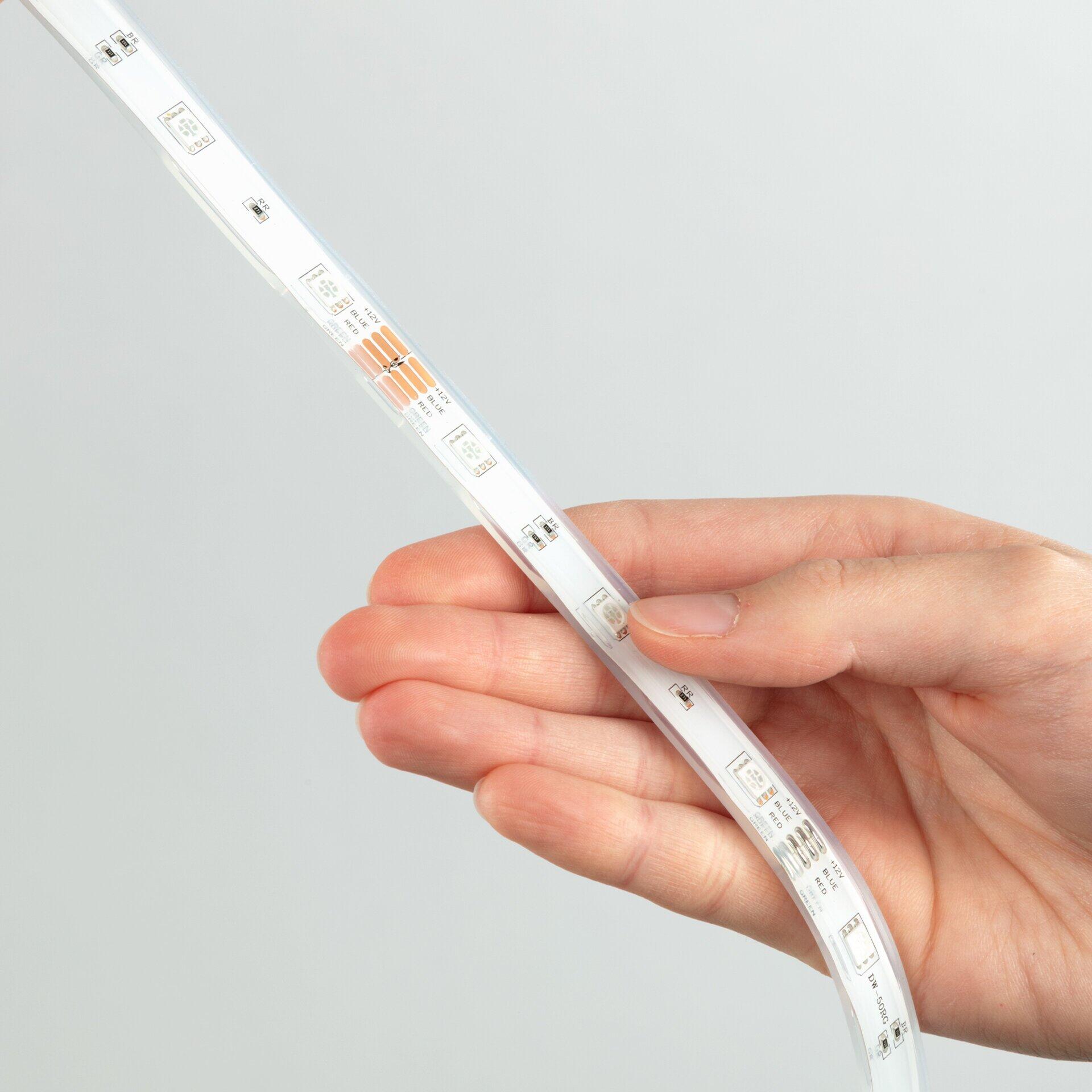 LED-Streifenband "Led Superline" mit leuchtenden LEDs und technischen Aufklebern, gehalten in der Hand vor neutralem Hintergrund.