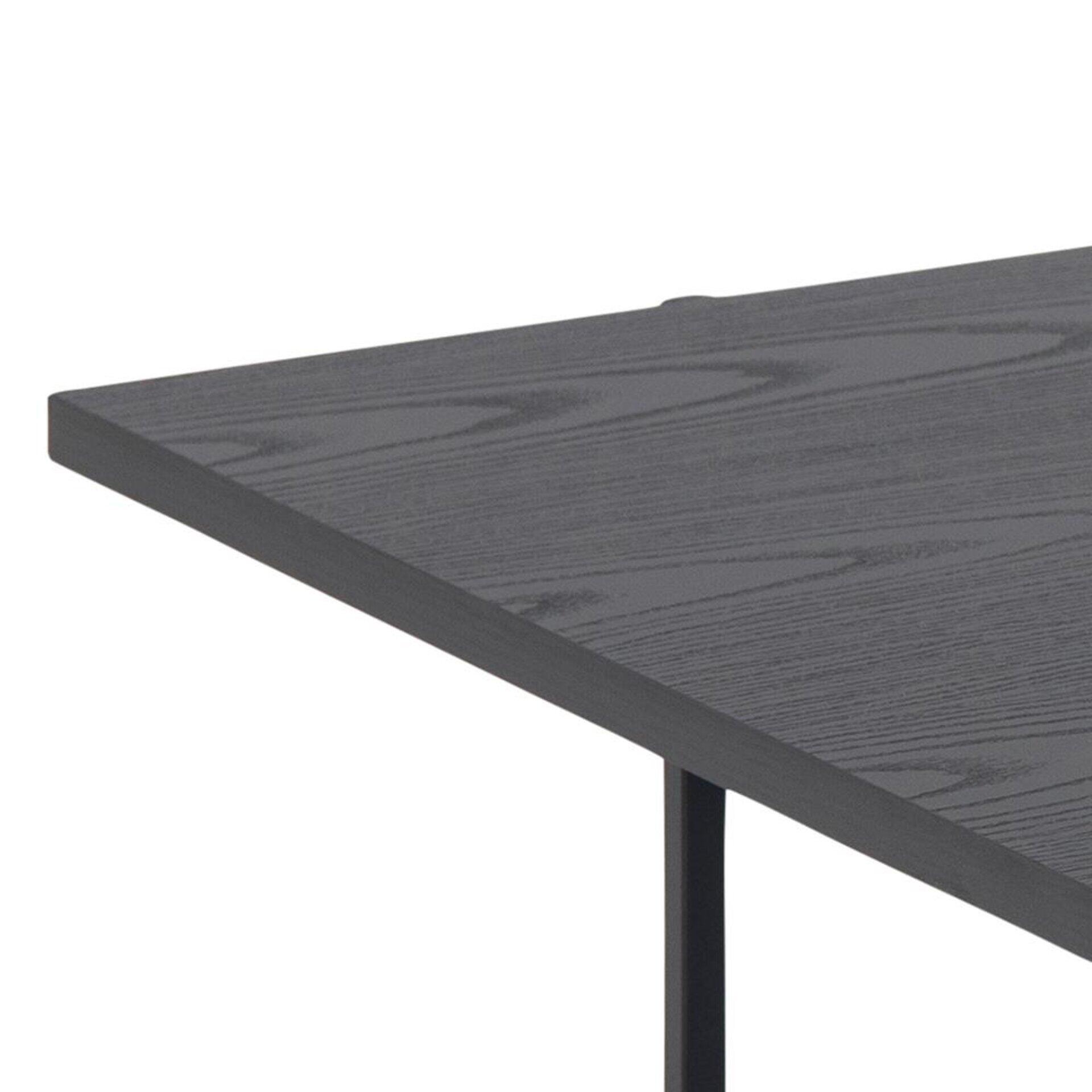 Detailaufnahme der schwarzen, massivholz-ähnlichen Tischplatte des Couchtisches Angus mit sichtbarer Maserung und einem schwarzen Metallbein.