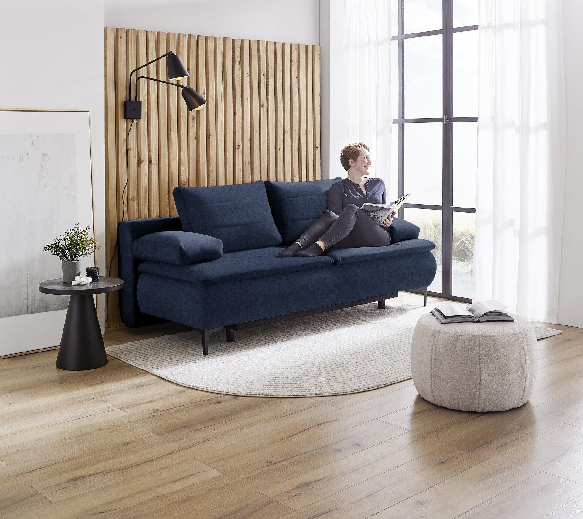 Dunkelblaues Boxspringsofa Melly mit breiter Rückenlehne und Auszieharretur in einem stilvollen Wohnzimmer.