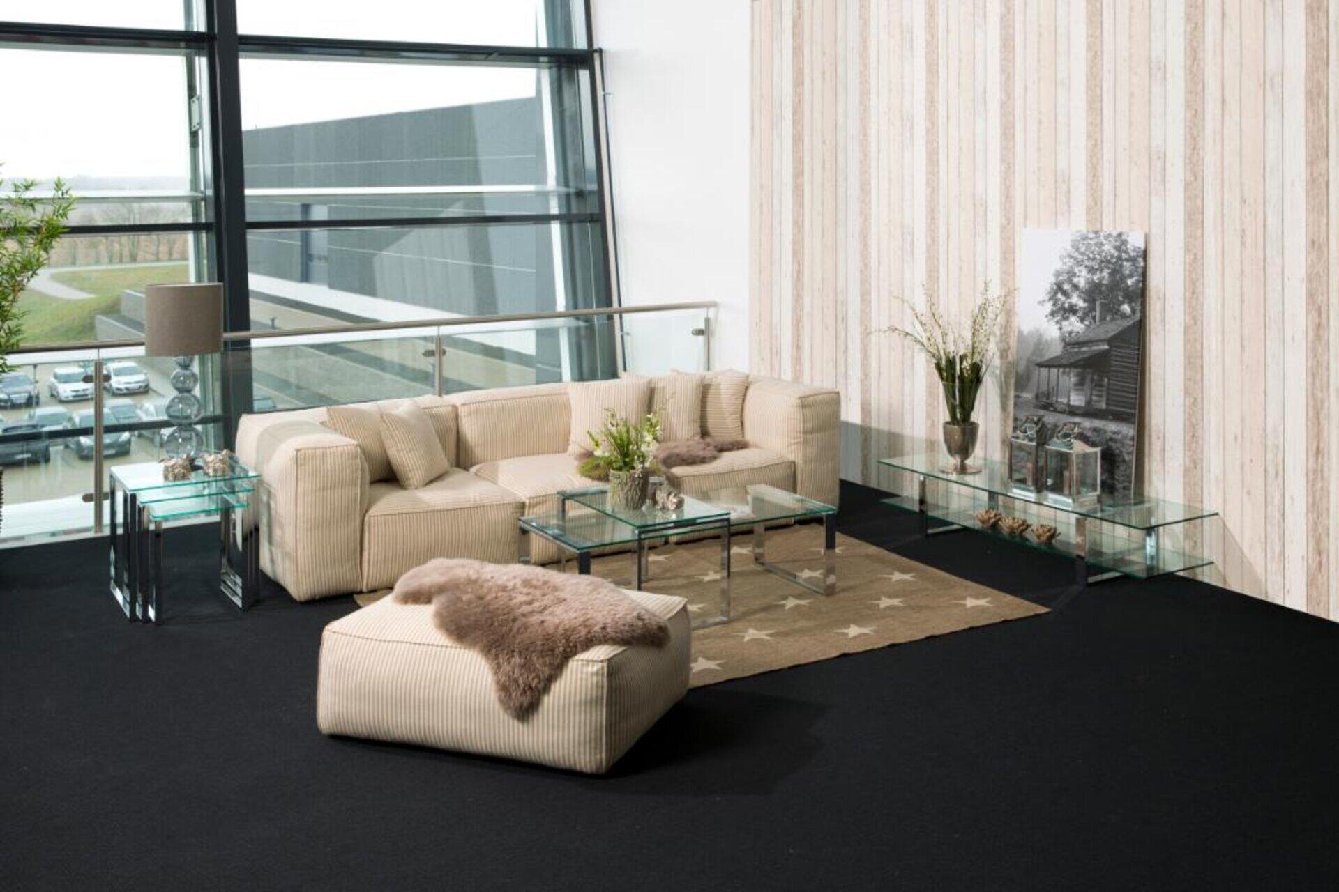 Couchtisch Katrine aus einem Set mit 3 Tischen vor einem beigen Ecksofa, aus leicht erhöhter Perspektive dargestellt.