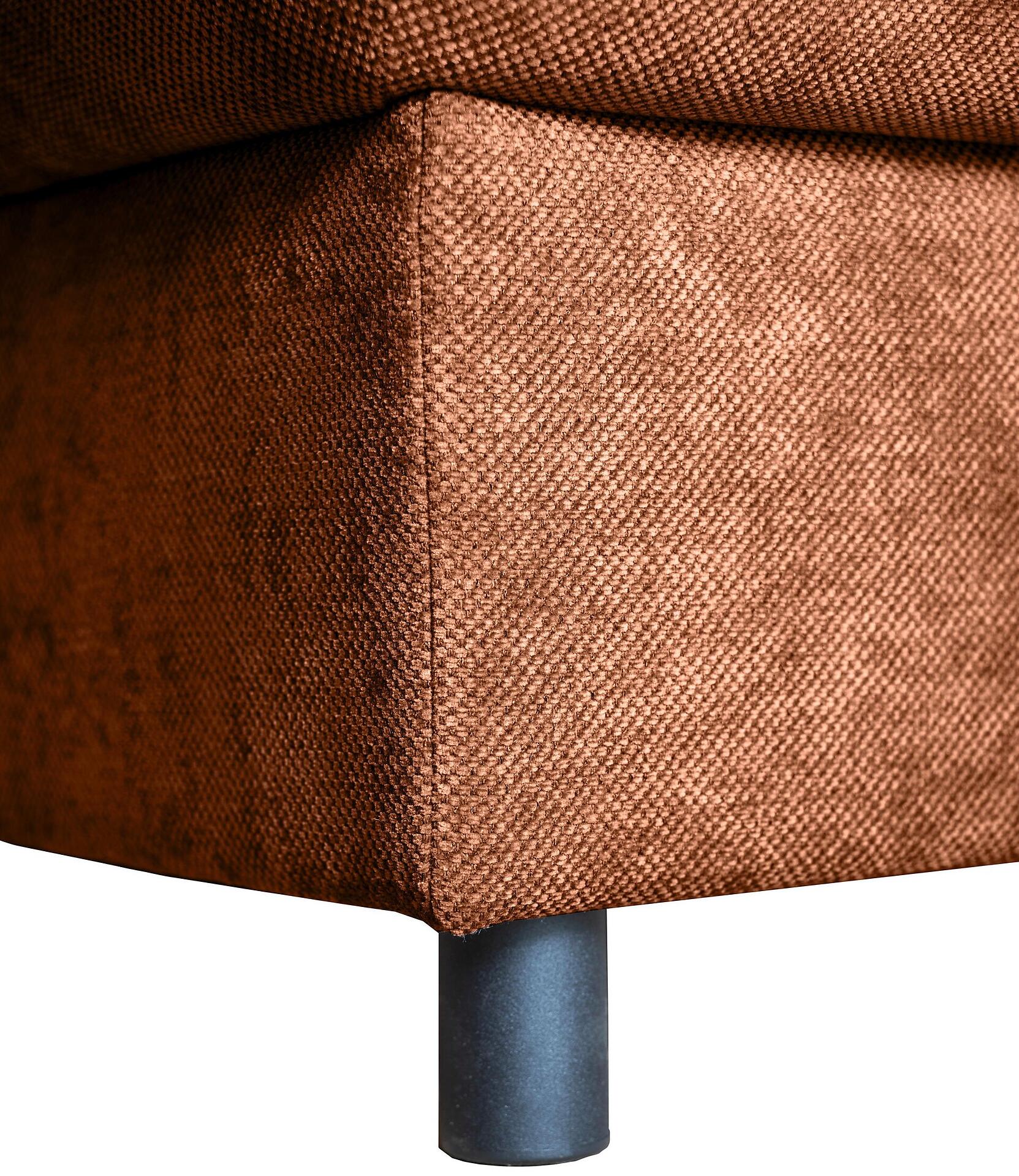 Detailaufnahme des braun-rot bezogenen Ecksofas Tokyo mit einem schwarzen Metallfuß, das die grobe Textur und die abgerundete Form des linken Seitenteils zeigt.