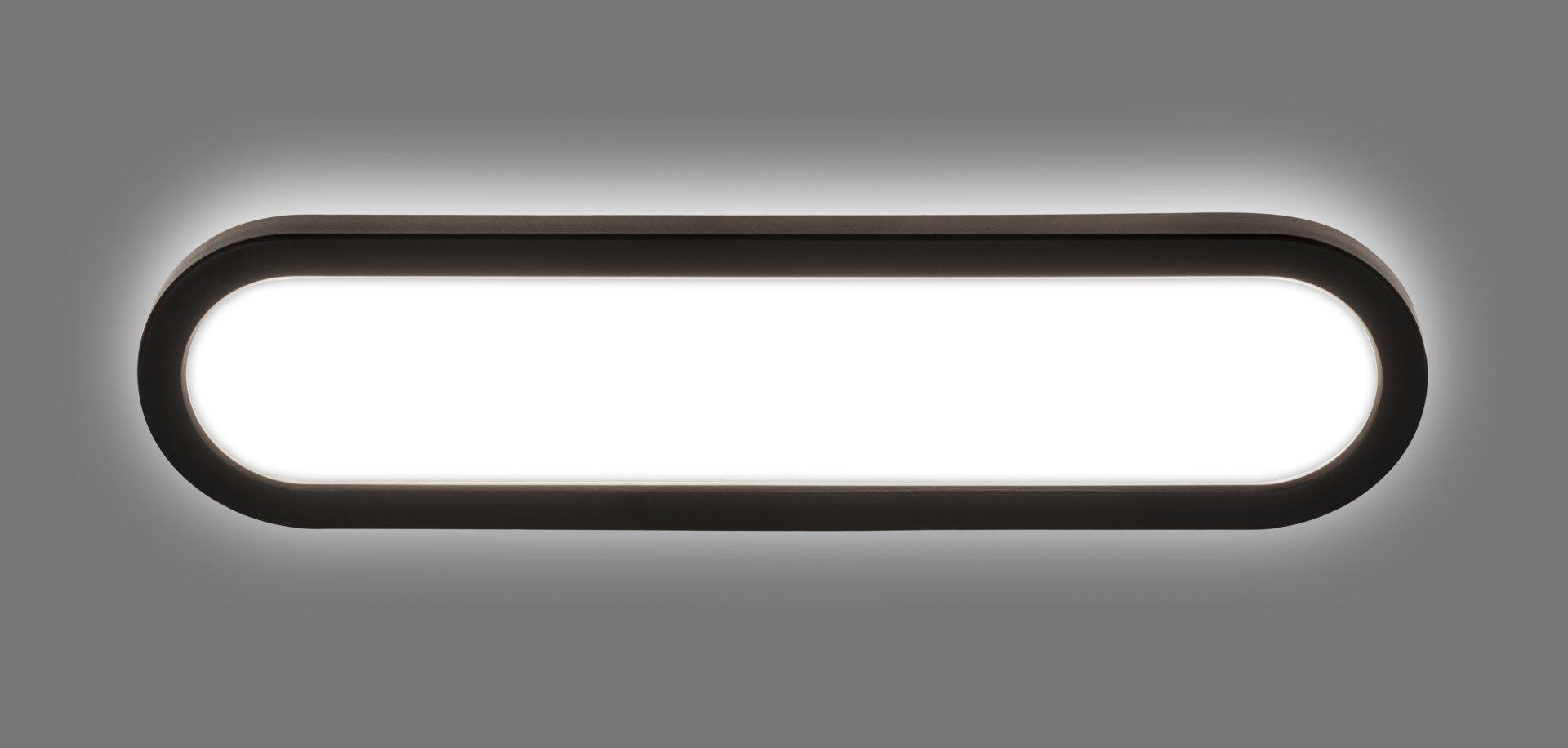 Schwarze Wandleuchte Pil im ovalen Design, dargestellt im Profil mit hellweißem Lichtschein.