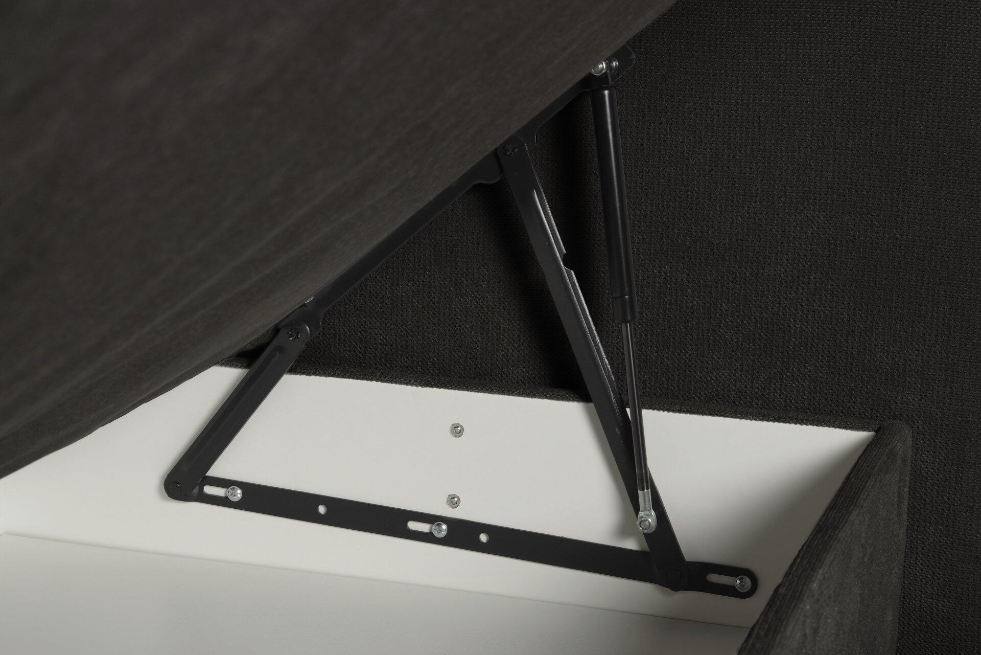 Detailaufnahme des Bettkastens des Boxspringbettes Portage BX2110: Stahl-Hebemechanismen ermöglichen das Anheben der Sitzfläche für den Zugang zum Fachboden.
