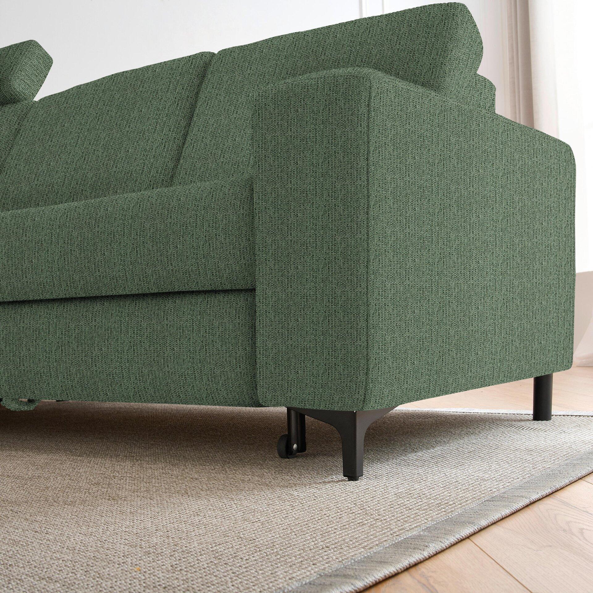 Grünes Ecksofa Balina mit breitem, quadratischen Armteil und schwarzen Metall-Winkelfüßen mit Rollen, aus einer seitlichen Perspektive.