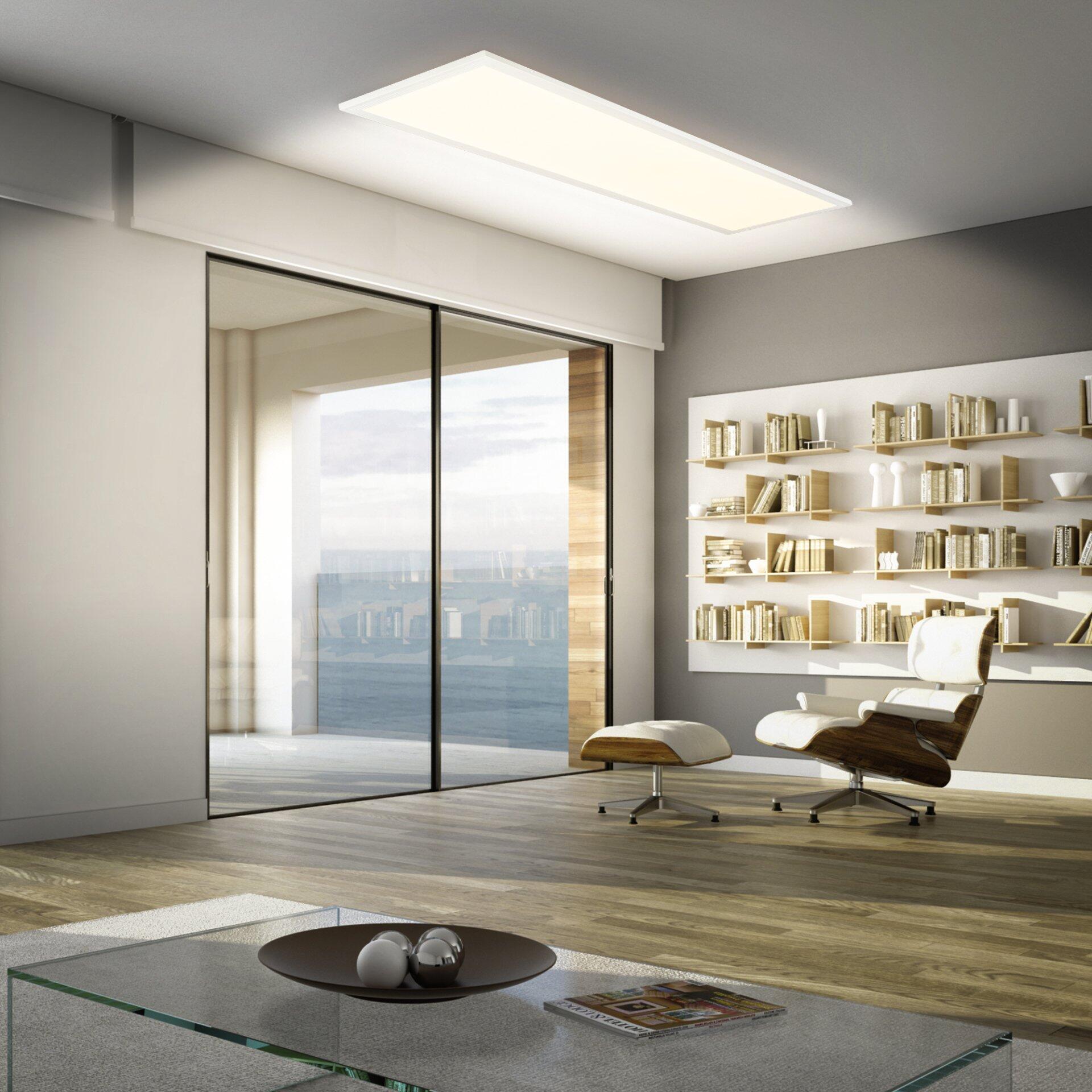 LED-Panel Piatto, integriert in eine moderne Wohnraumgestaltung, spendet diffuses Licht und setzt Akzente auf einen Couchtisch mit Glasplatte und filigranem Metallgestell.