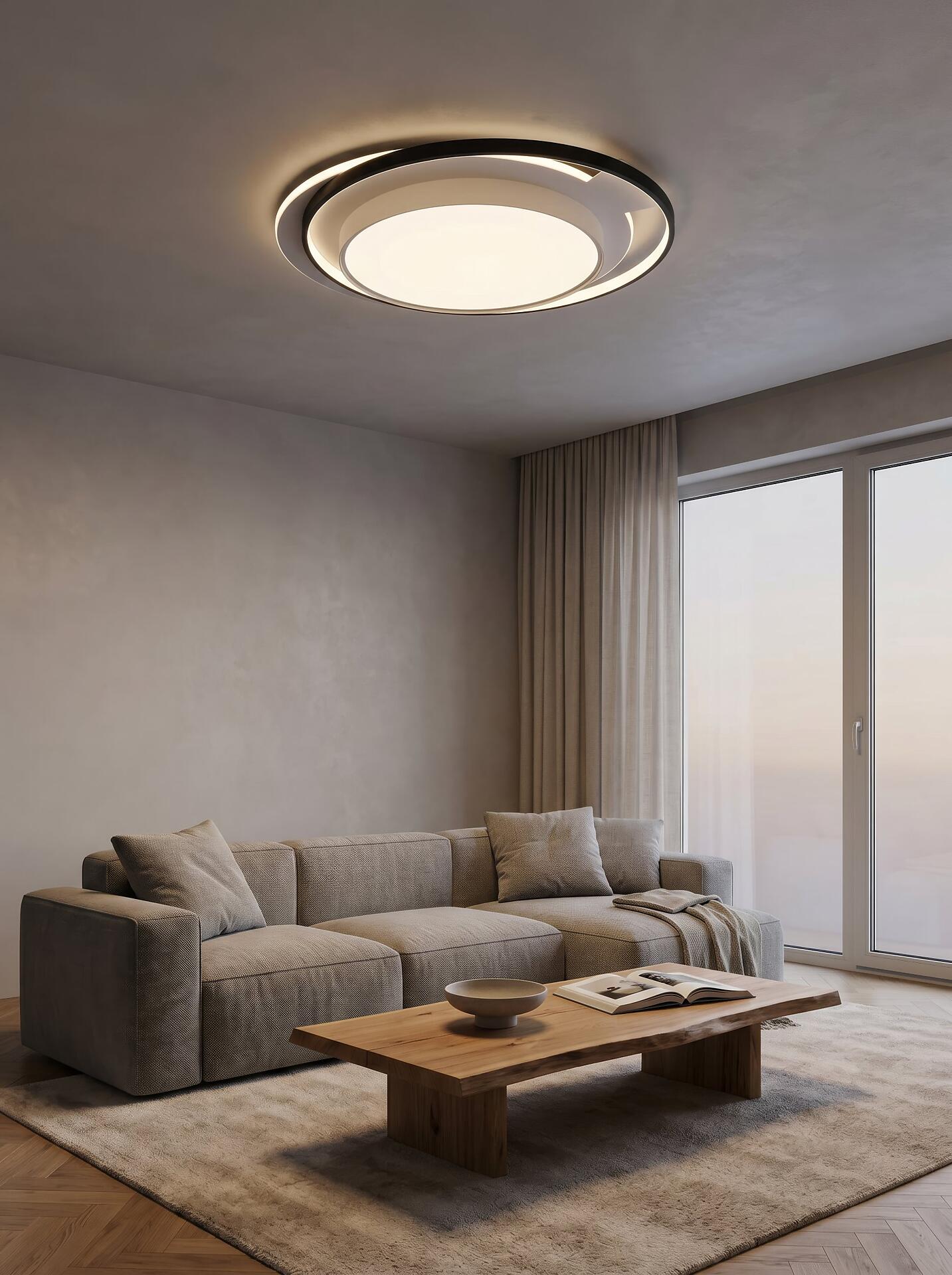 Deckenleuchte Ceru mit konzentrischen, kreisförmigen Beleuchtungselementen, die einen warmen Lichtschein über dem Couchtisch erzeugt.