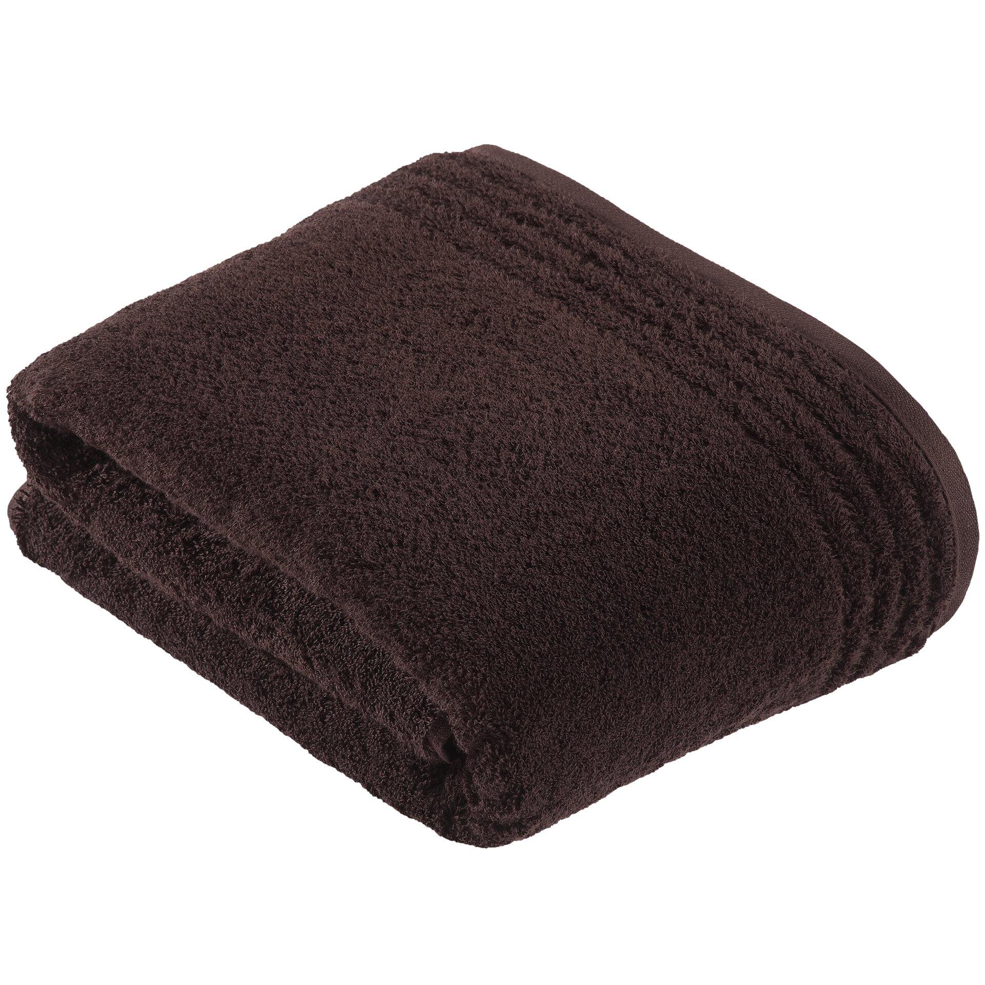 Dunkelbraunes ViennaStyleSupersoft Badetuch, quadratisch gefaltet und aus nächster Nähe in leicht schräger Perspektive fotografiert, um die weiche Textur und die Faltbarkeit zu zeigen.
