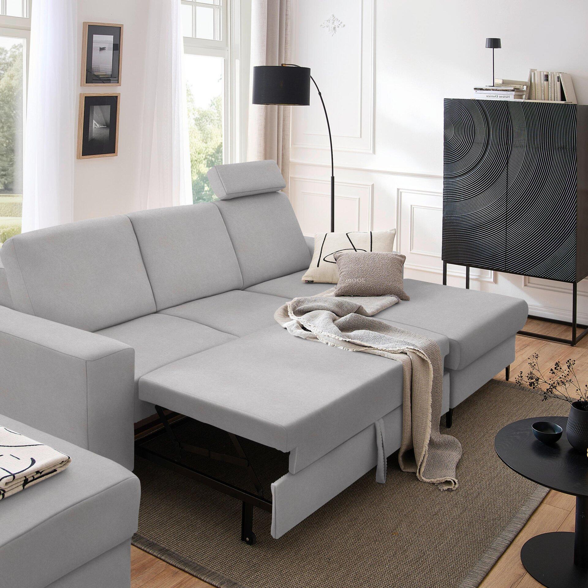 Ecksofa Balina in L-Form mit Bettkasten und Ausziehfunktion für eine Schlaffläche, abgebildet aus erhöhter Perspektive in einem hellen Wohnzimmer.
