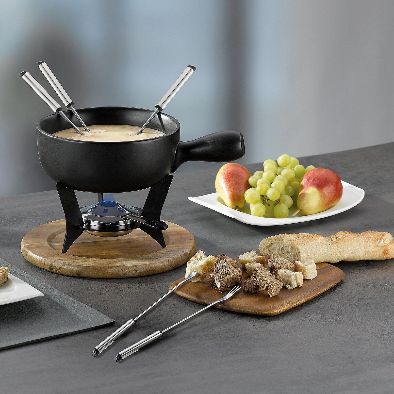 Käsefondue-Set "Country" mit schwarzem Keramiktopf, Brenner und zwei Fonduegabeln, serviert mit Baguette, Obst und regulierbarer blauer Flamme.