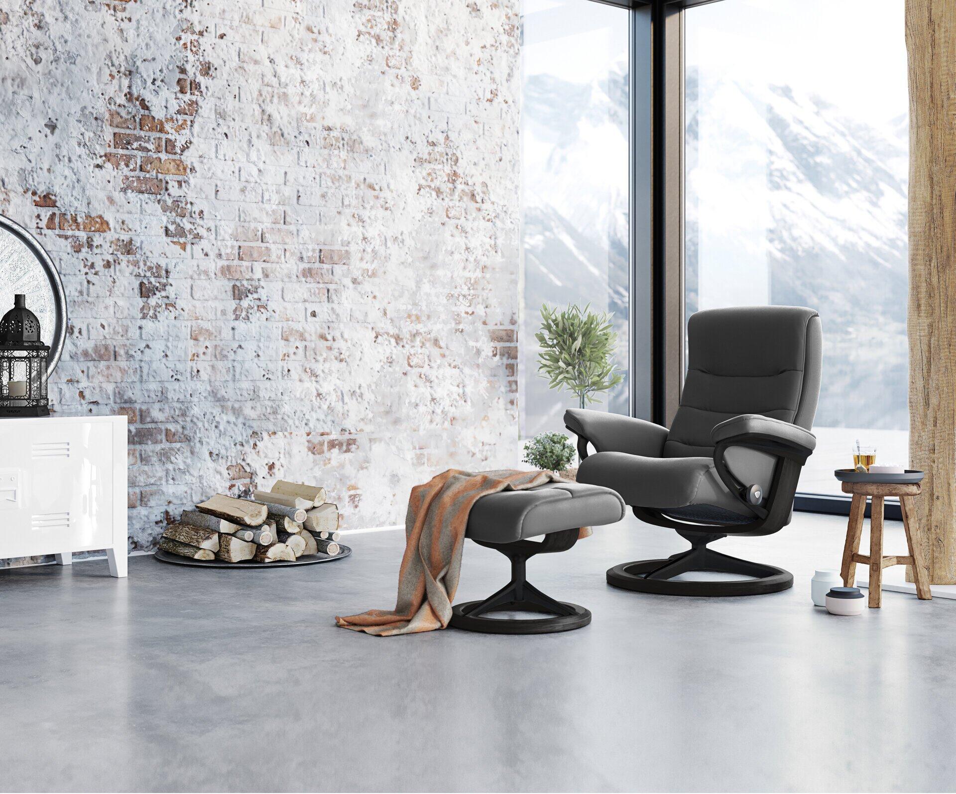 Relaxsessel Nordic mit Fußhocker vor rustikalem Hintergrund, der die verstellbaren Funktionen und die ergonomische Formgebung betont.