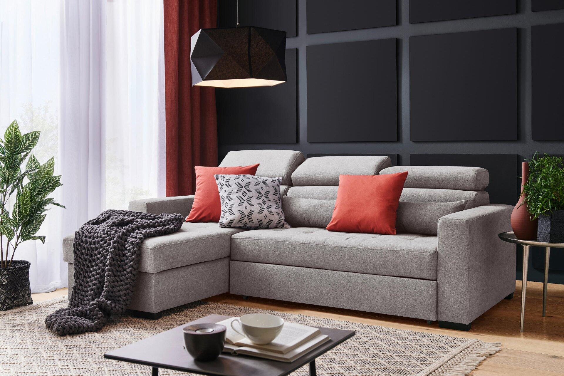 Graues Ecksofa Monson mit linksseitiger Chaiselongue und mehrfach verstellbarer Kopfstütze, dargestellt in einem stilvollen Wohnzimmerambiente.