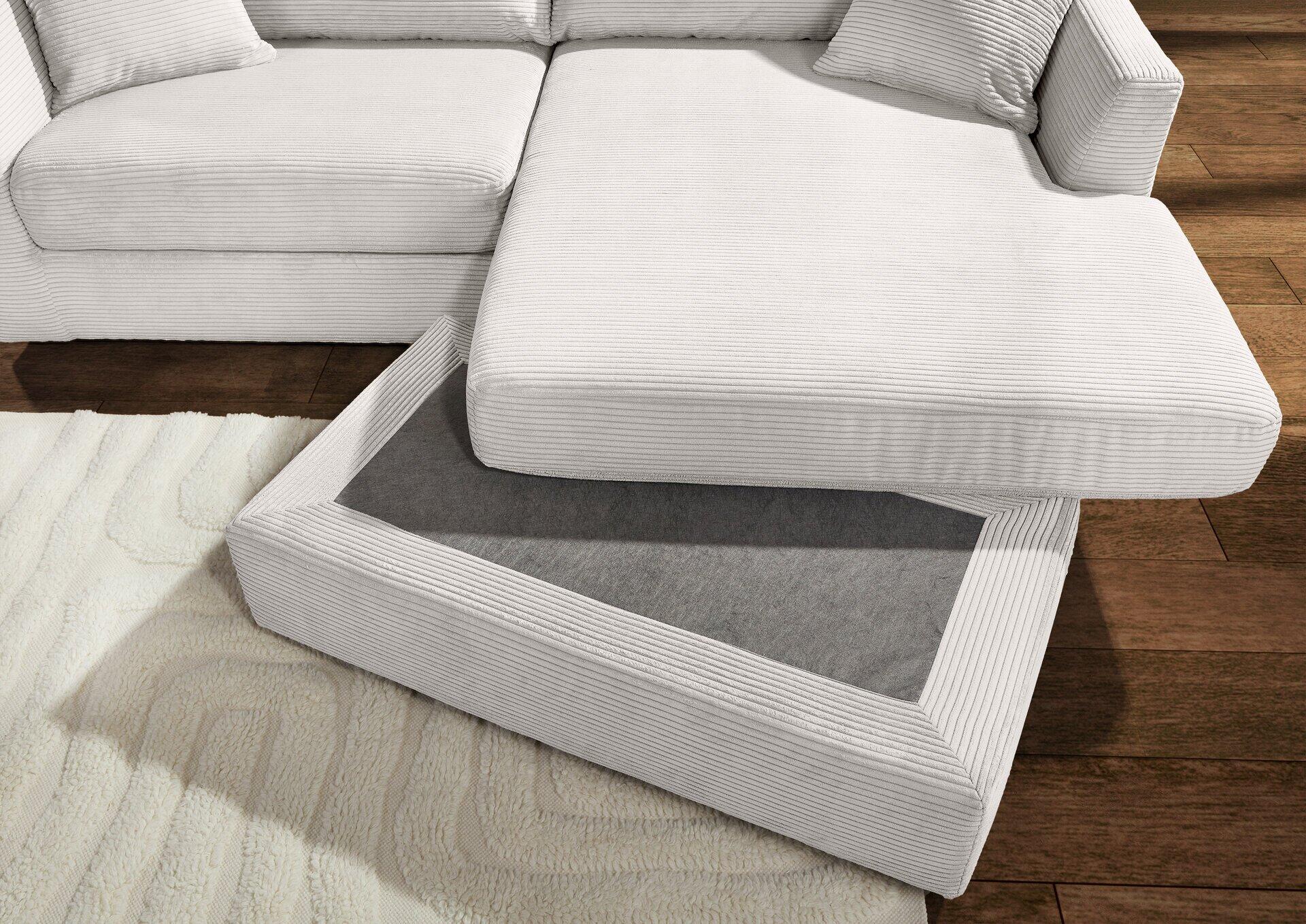 Weißes, modernes Sofa mit Eckausziehelement und integriertem, dunkelgrau gefüttertem Stauraum, leicht unterhalb und schräg aufgenommen.