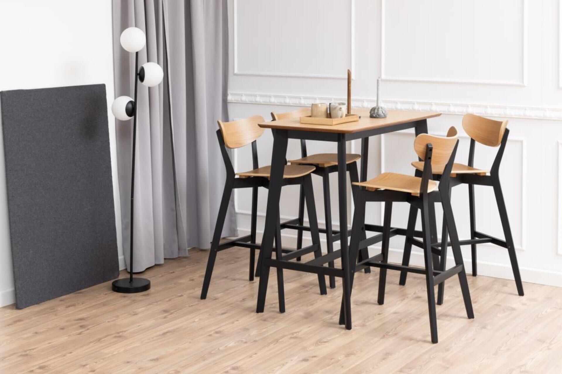Roxby Bartisch mit Barhockern, Detailaufnahme einer modernen Essgruppe mit erhöhter Perspektive, die die Tischfläche und die leicht geneigten Rückenlehnen der Barhocker zeigt.