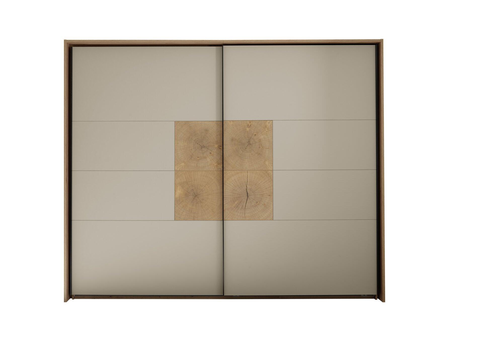 Schwebetürenschrank Sindara mit zwei cremefarbenen Türen, die horizontal gleiten und im oberen Bereich der linken Tür ein dekoratives Element mit Holzmaserung aufweisen.