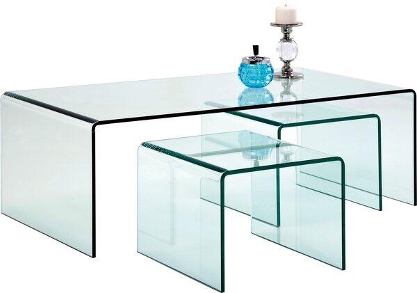 Couchtisch Clear Club (3/Set) aus transparentem Glas mit integrierbarem Untertisch und filigranem Metallgestell, dargestellt in einer Vogelperspektive mit dekorativen Elementen auf der Tischplatte.