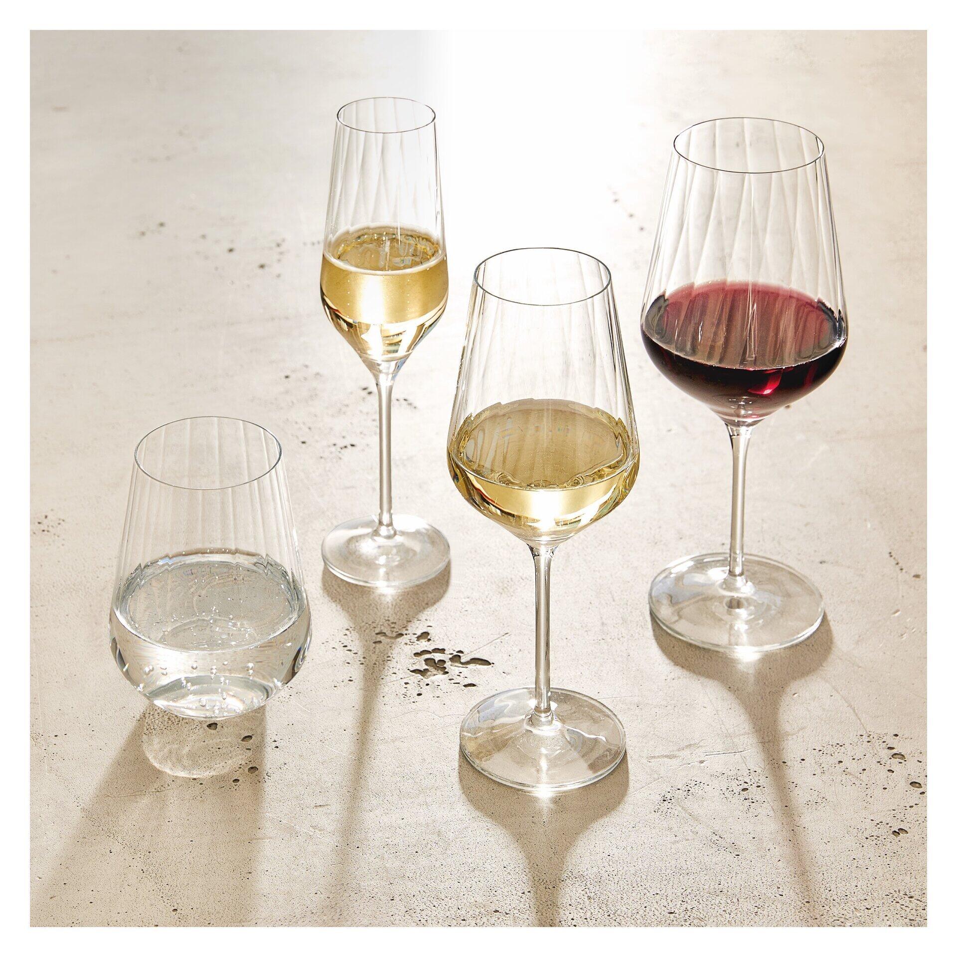 Champusglas-Set: Vier Gin-Gläser mit reliefierter Struktur auf einem hellen Untergrund, wobei ein Glas mit klarem Wasser und zwei mit Weiß- und Rotwein gefüllt sind, um die Form und das Design zu präsentieren.