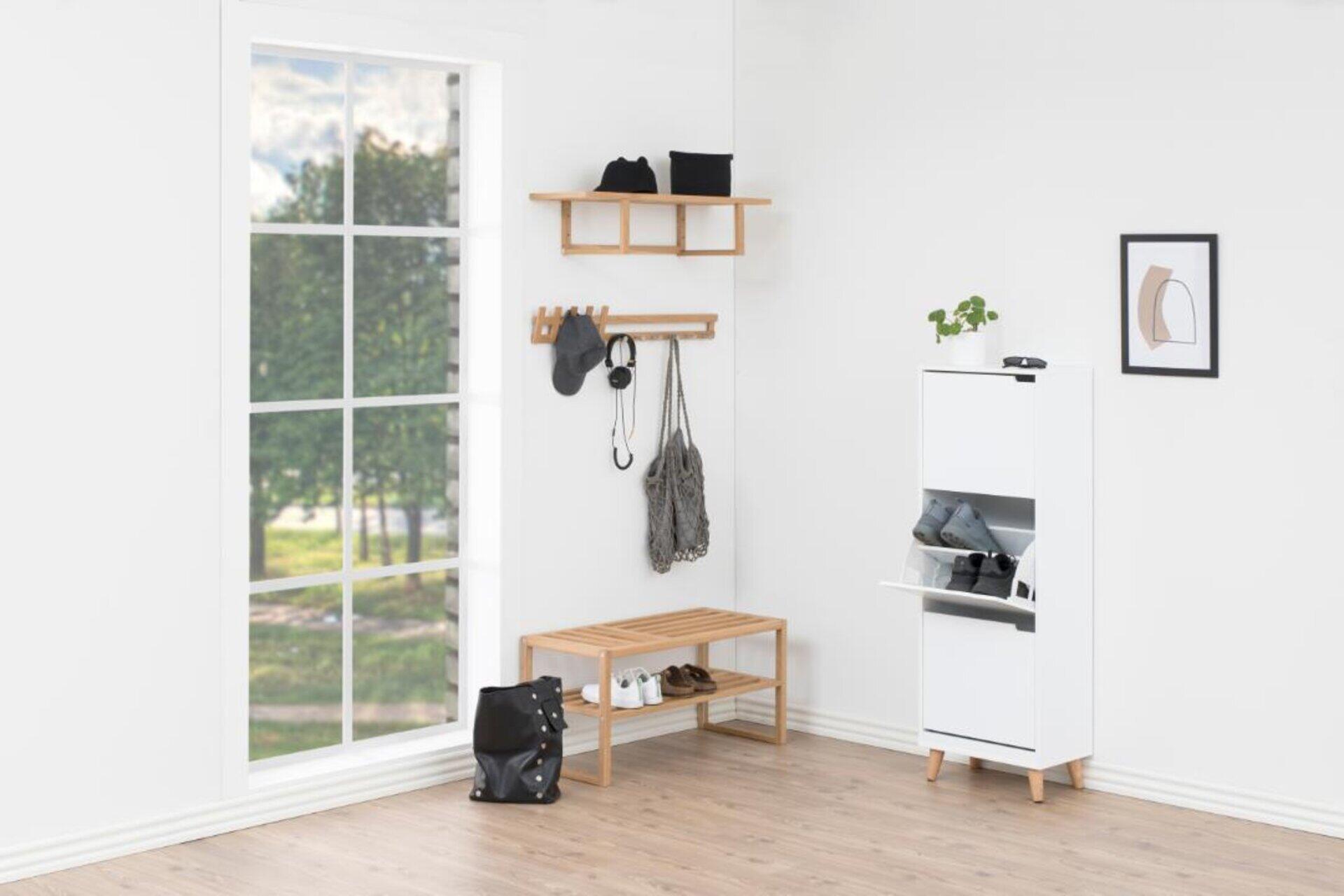 Weiß lackierter Schuhschrank Mitra mit drei Schüben und Ablageflächen, eingebettet in einen hellen, modernen Eingangsbereich mit passender Bank und Hängebrett.