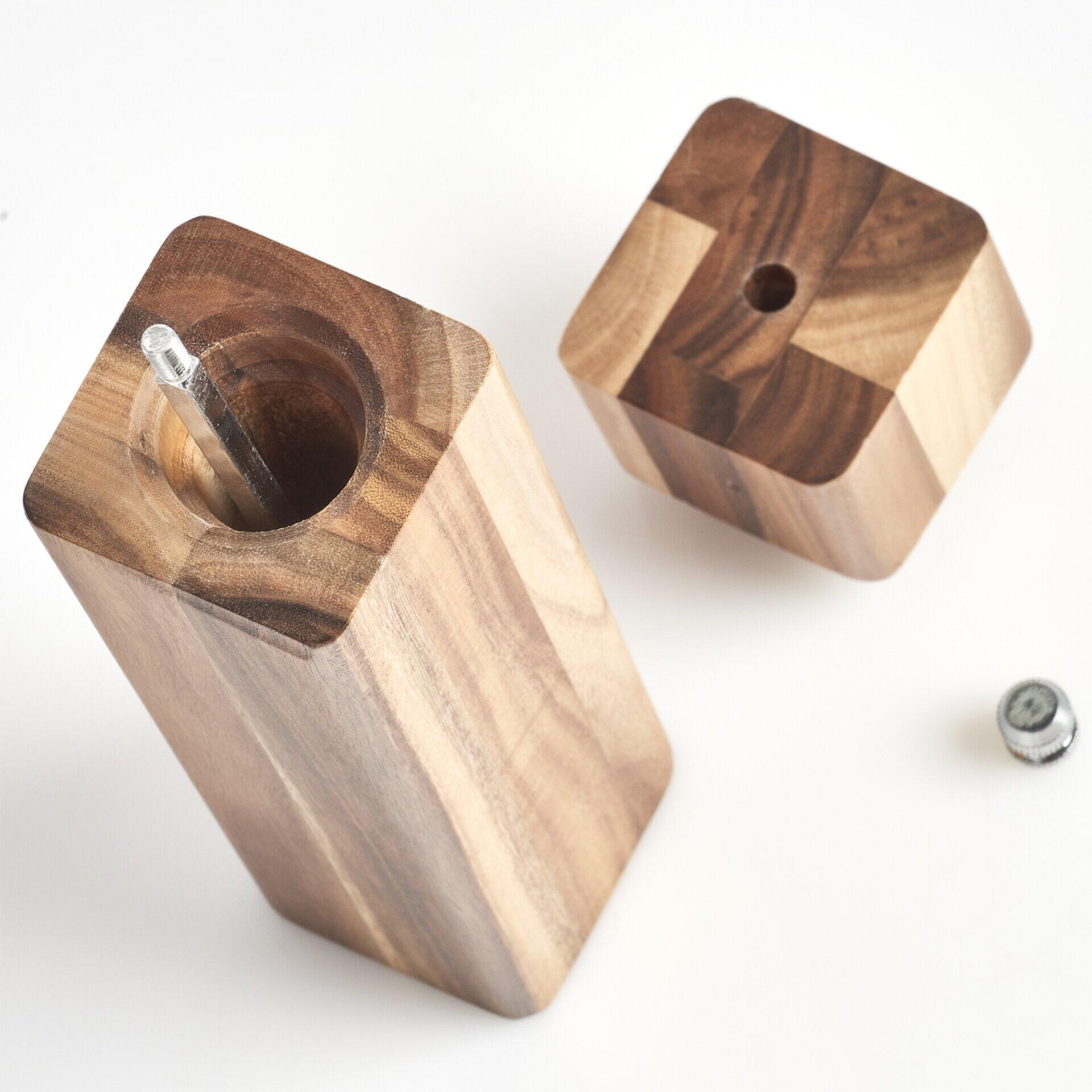 Salz- und Pfeffermühle aus Holz, Detailaufnahme der sechseckigen und runden Oberseiten mit silbernem Metallstift, leicht erhöhte Perspektive.