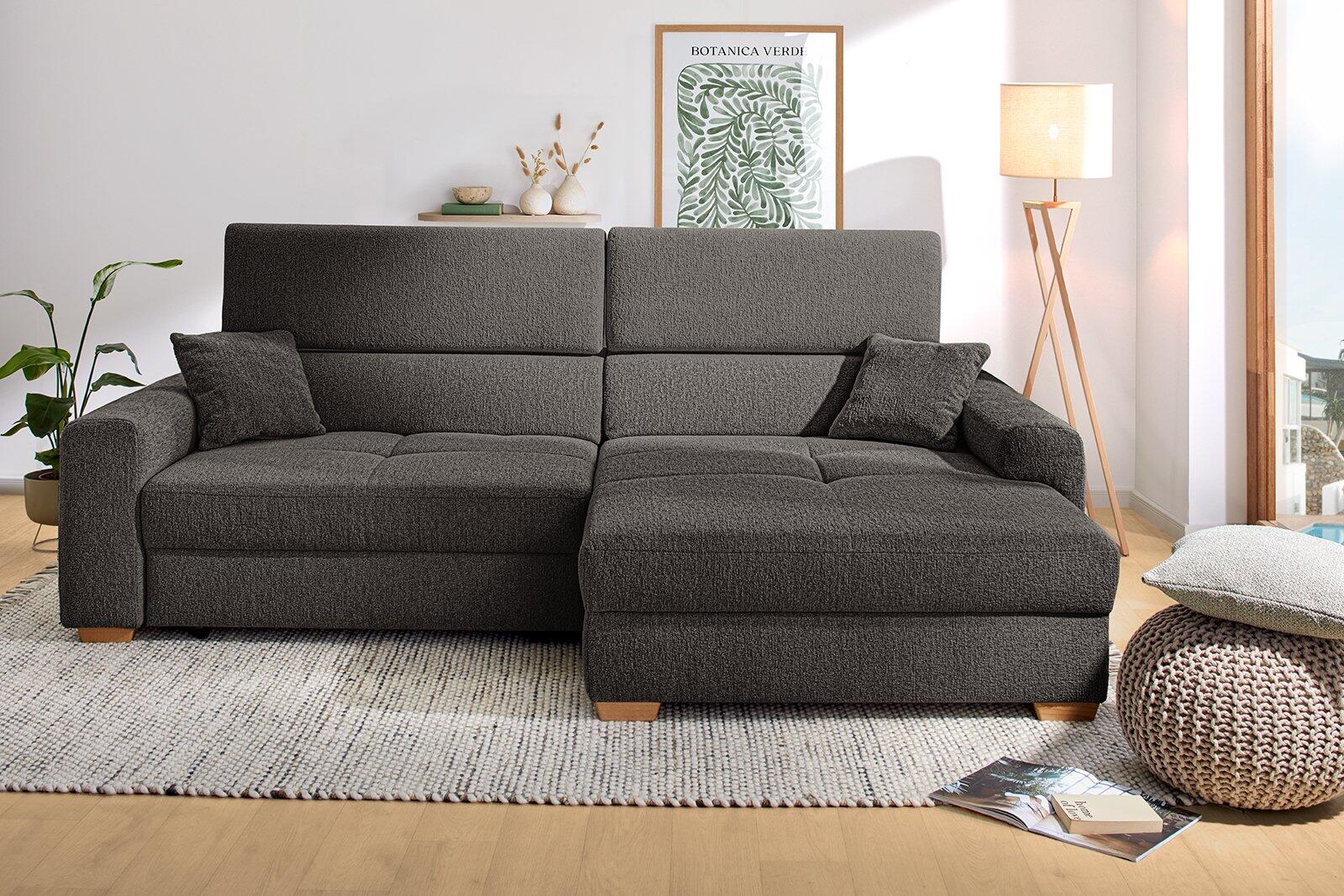 Graues Wohnsofa mit rechts oder links montierbarer Schwenktür und hochklappbarer Sitzfläche für eine Schlaffläche.