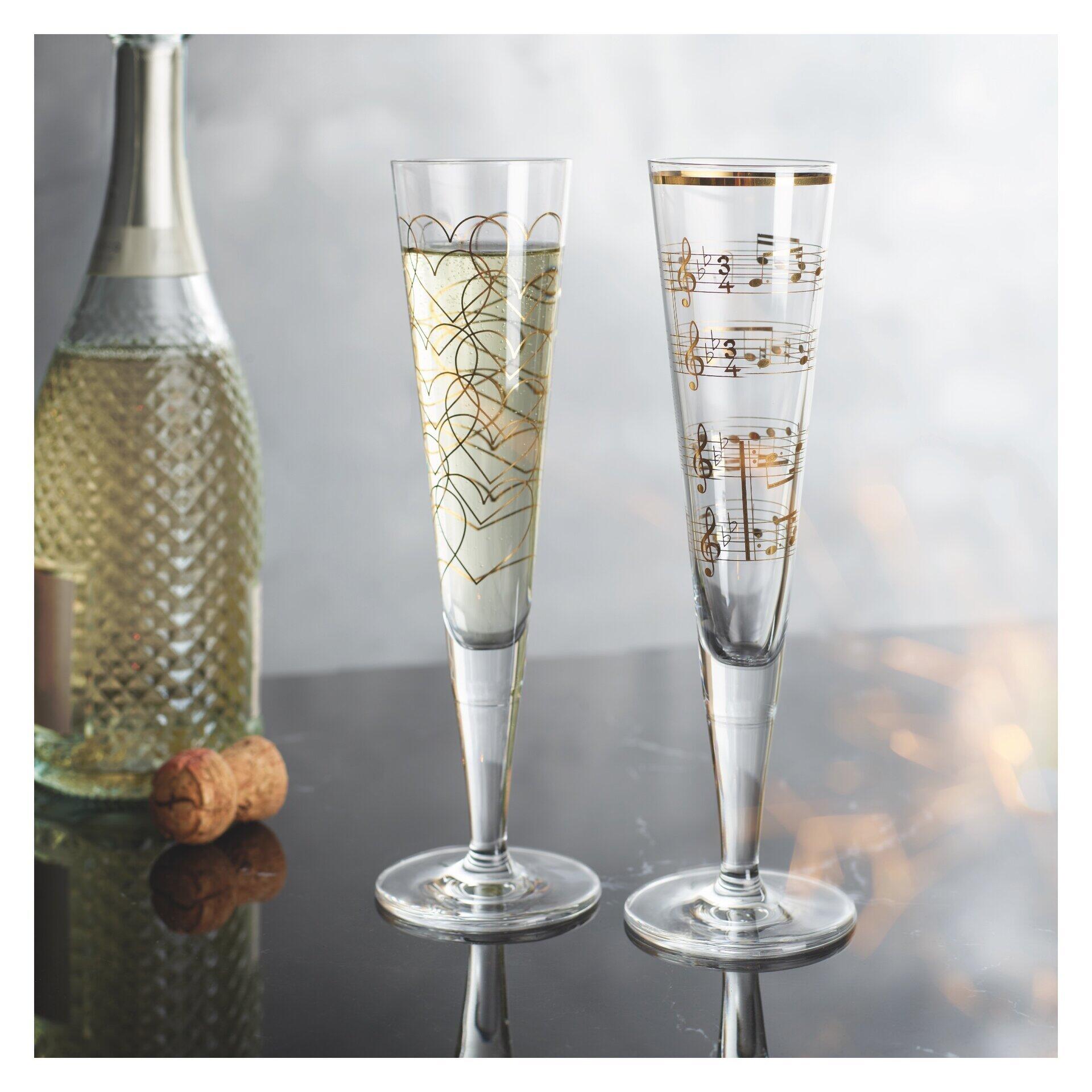 Zwei Champagnergläser mit goldenen Noten-Verzierungen, hochformatig und elegant präsentiert in einer Geschenkbox.