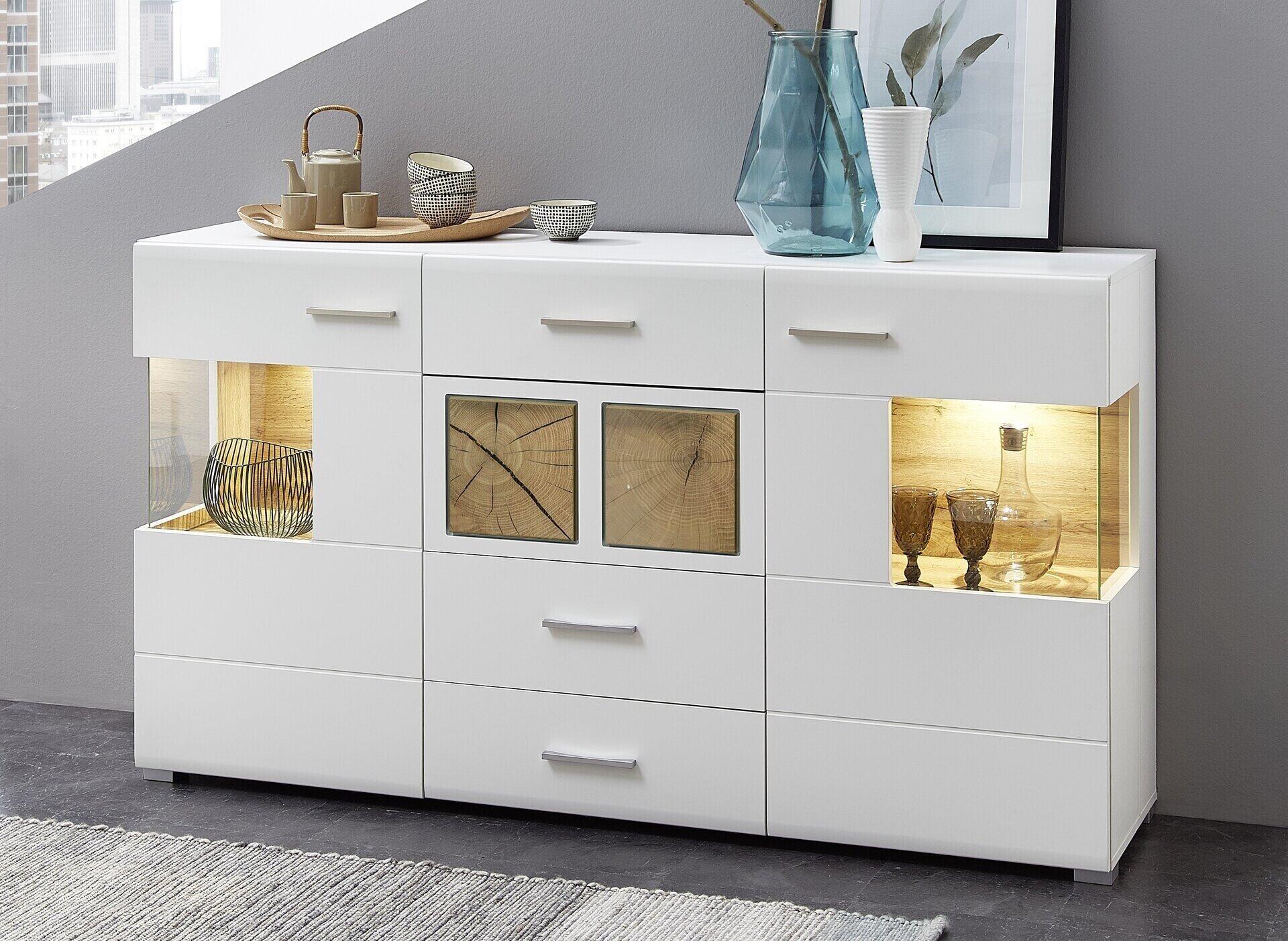Sideboard Fun Plus mit weißen Fronten, Glastüren und LED-Beleuchtung, zeigt dekorative Elemente auf den beleuchteten Ablageflächen.