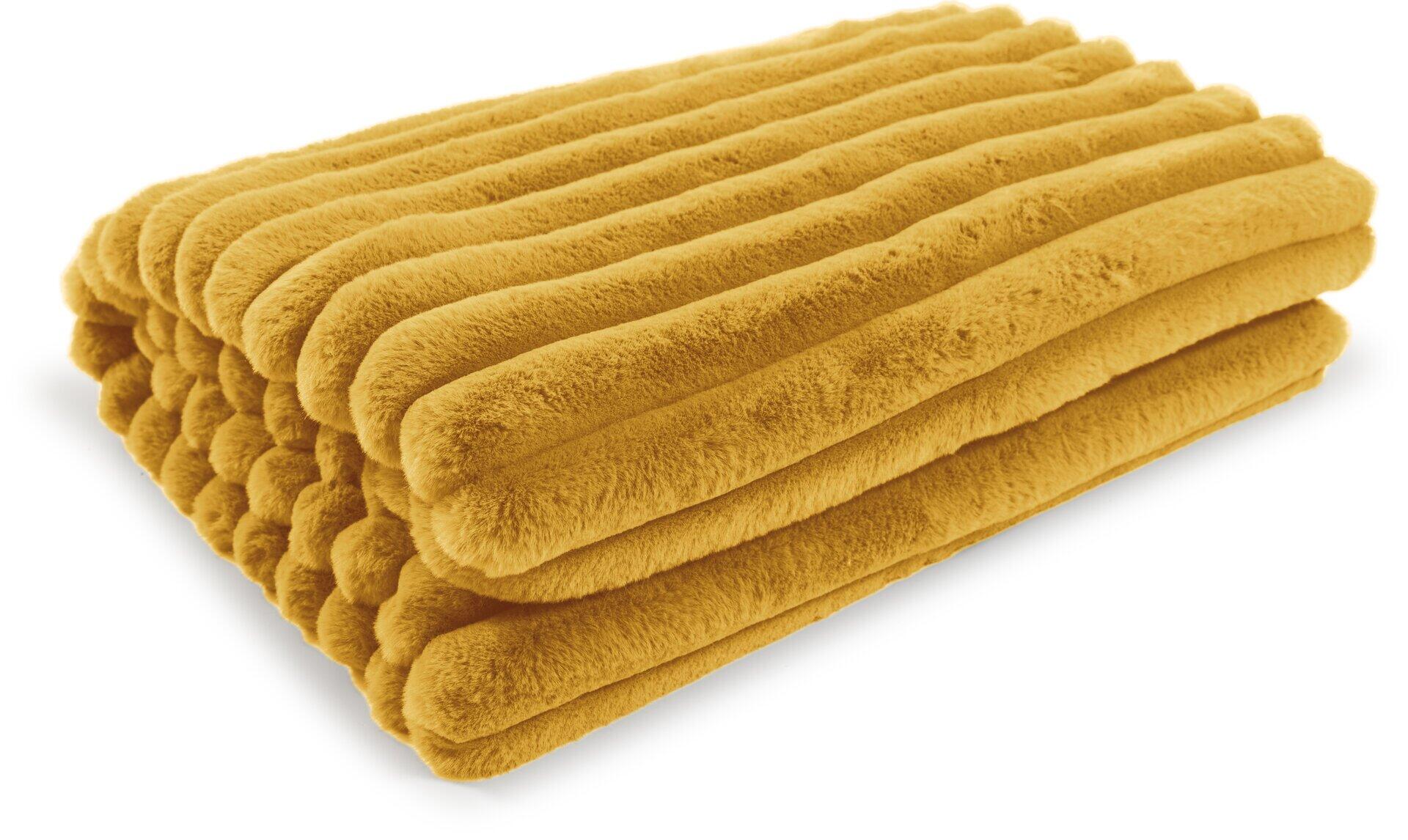 Flauschiges, gelbes Kissen Raya mit Fellimitatstreifen auf weißem Hintergrund, das in mehreren Falten gelegt ist, um die Textur und das Volumen zu betonen.
