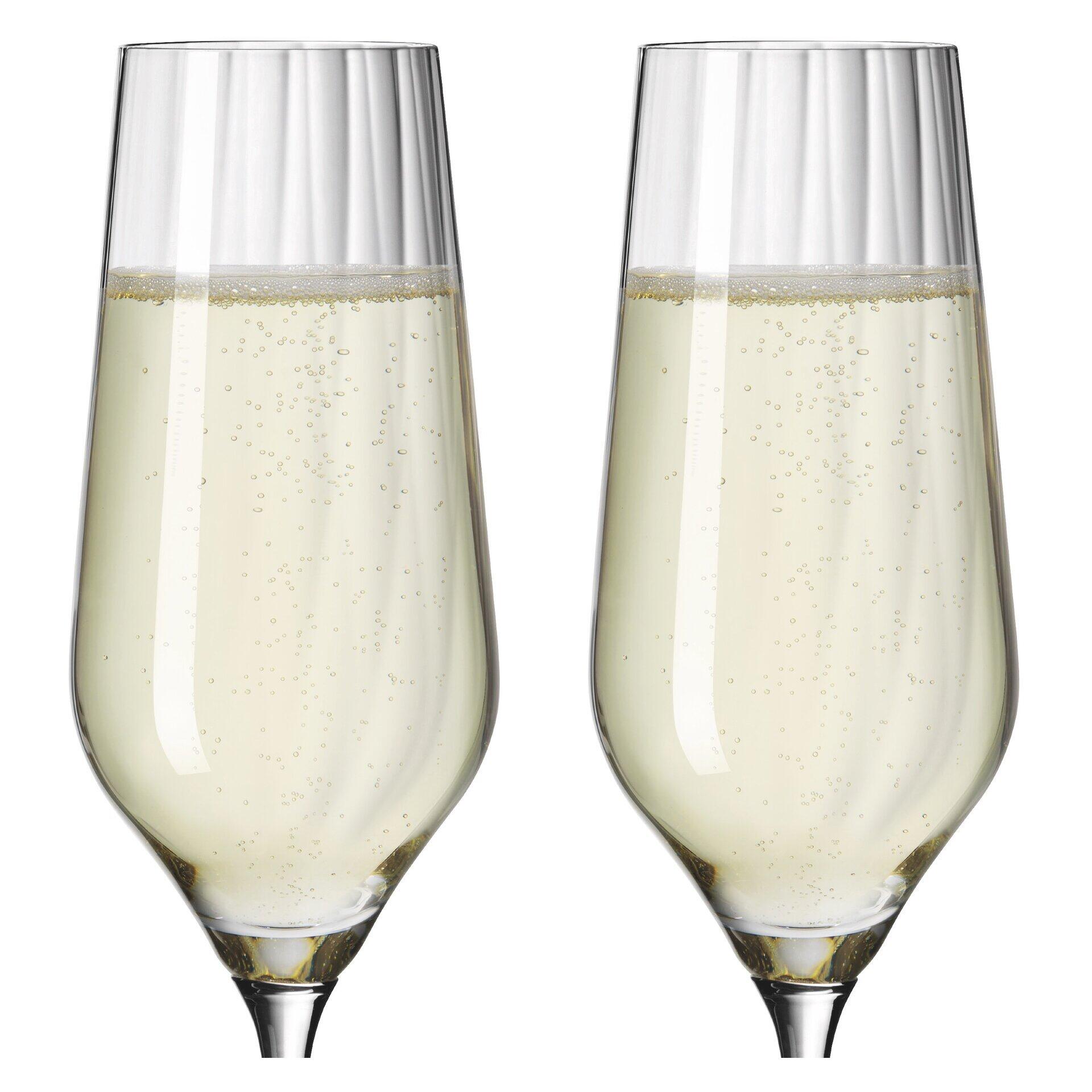 Zwei Champagnergläser mit reliefierter Struktur und schlanker, konischer Form, gefüllt mit perlendem Getränk, präsentiert in einer Geschenkbox.