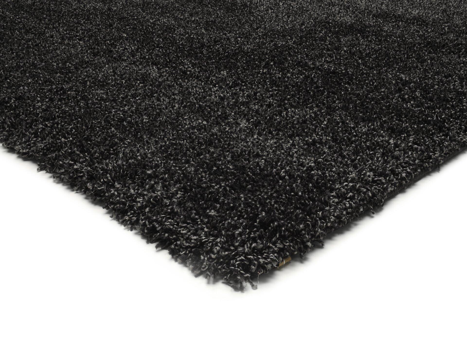 Detailaufnahme des Maschinenwebteppichs Erdara aus der Vogelperspektive, die die flauschige, dunkle Hochflor-Textur aus 100% Polypropylen zeigt.