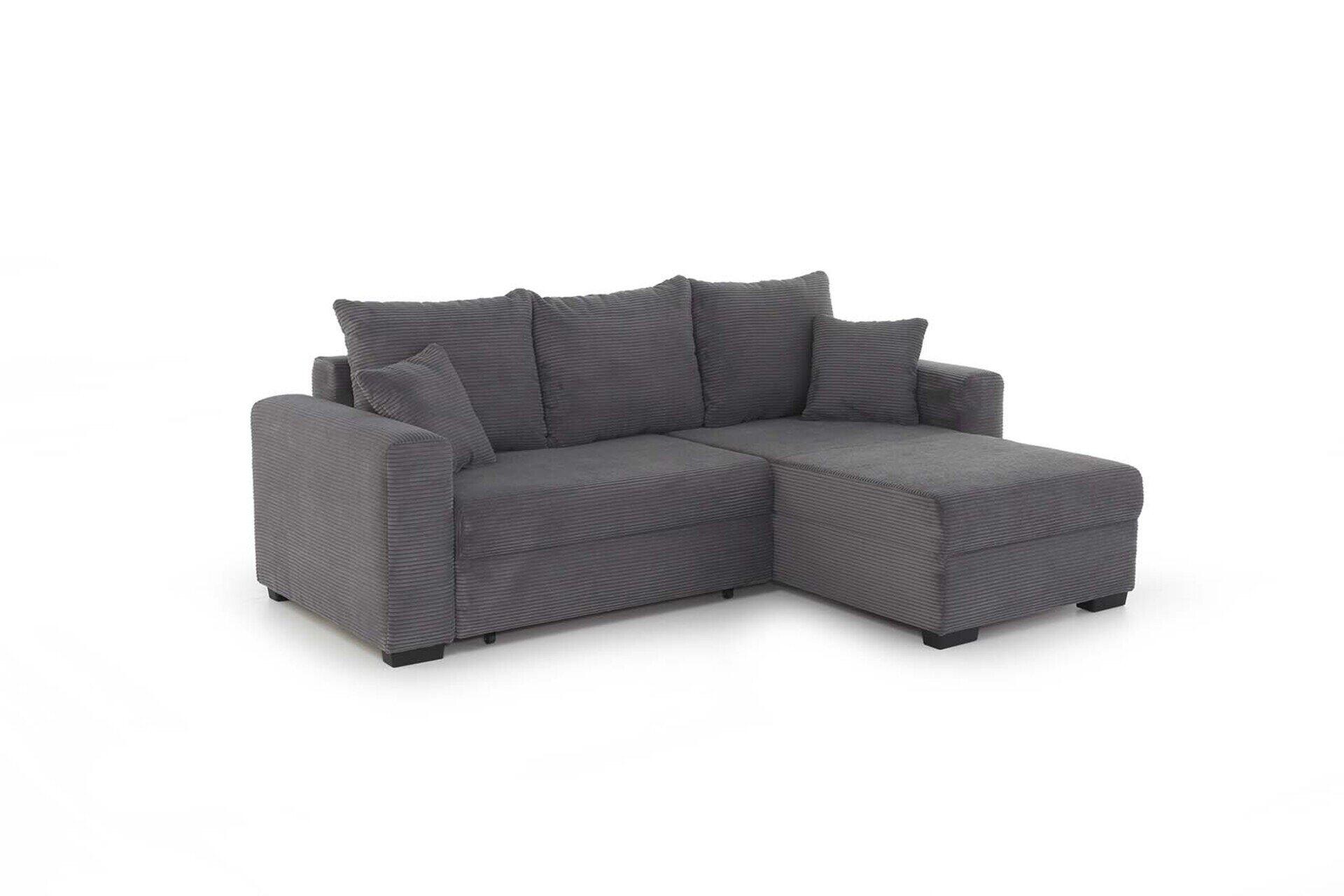 Graues Ecksofa Elmau mit Ottomane auf weißem Hintergrund, zeigt die strukturierte Oberfläche der Kissen und die Möglichkeit zur flexiblen Anordnung des Fußhockers.
