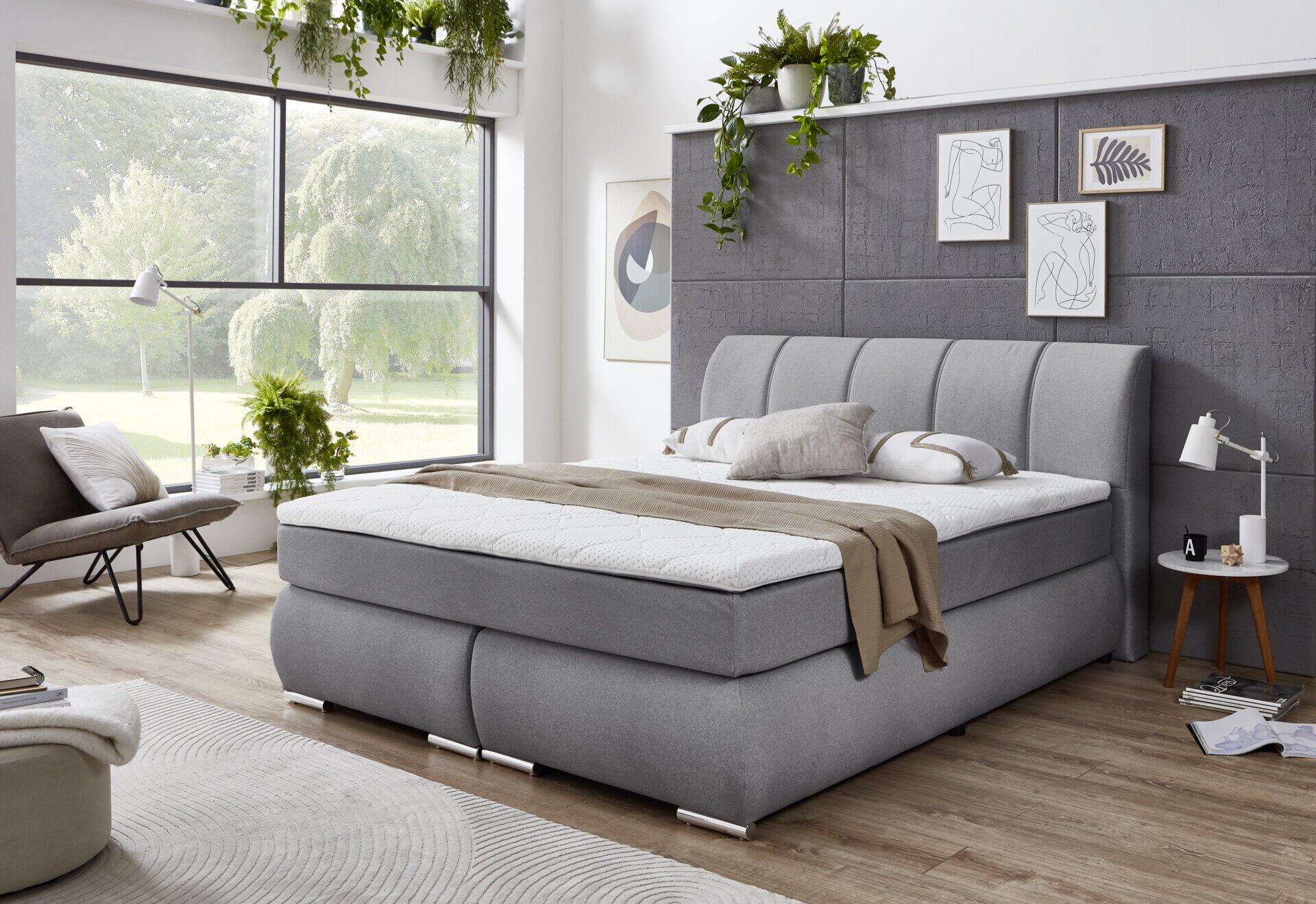 Detailaufnahme des grauen Kopfteils des Boxspringbettes Graz BX2630 mit vertikalen Linien und einer weiß-genoppten Matratze.
