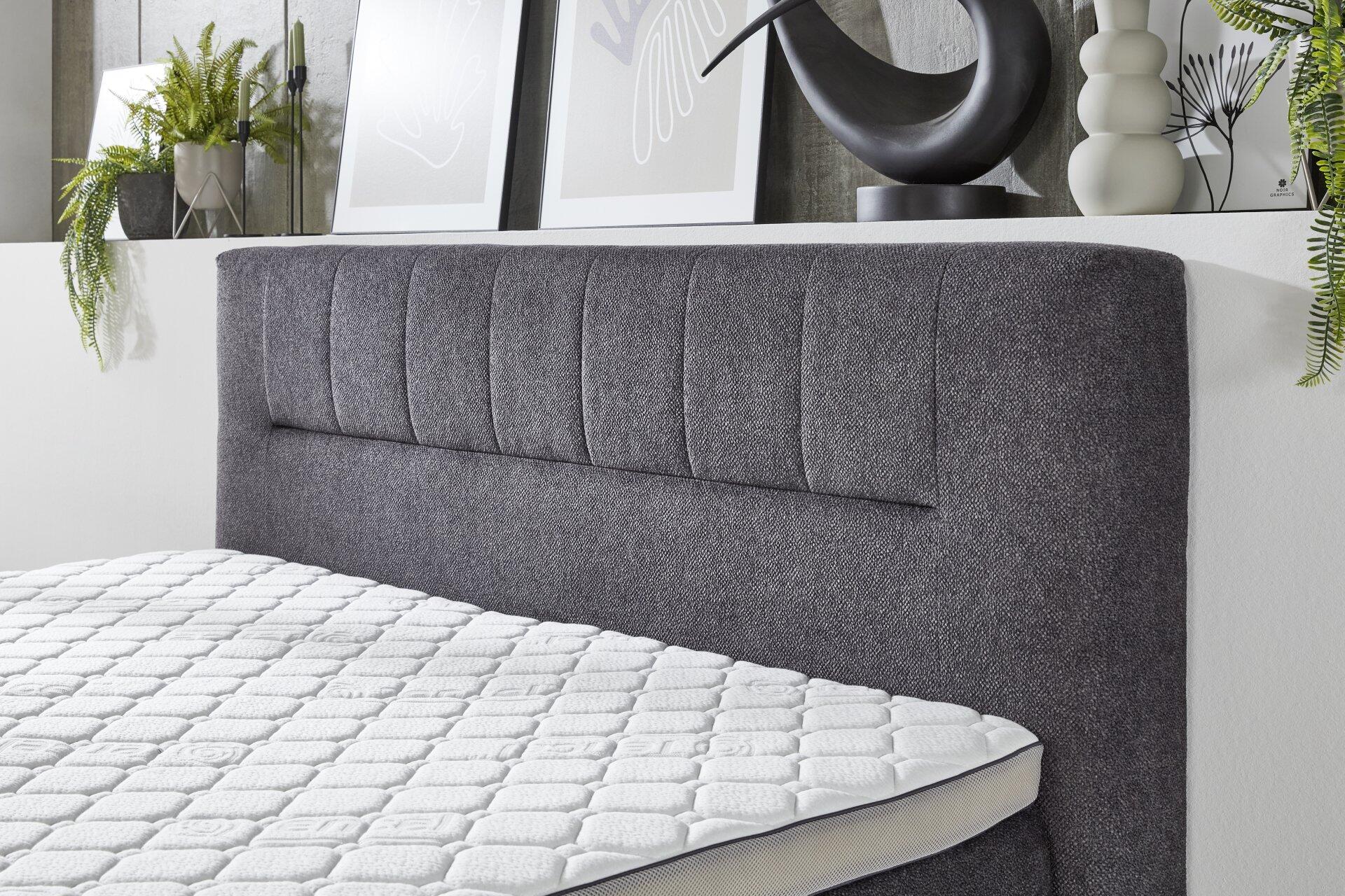 Boxspringbett Kenosha BX2450 mit reliefartiger Matratzenoberfläche und grauem Kopfteil mit vertikalen Feldern.