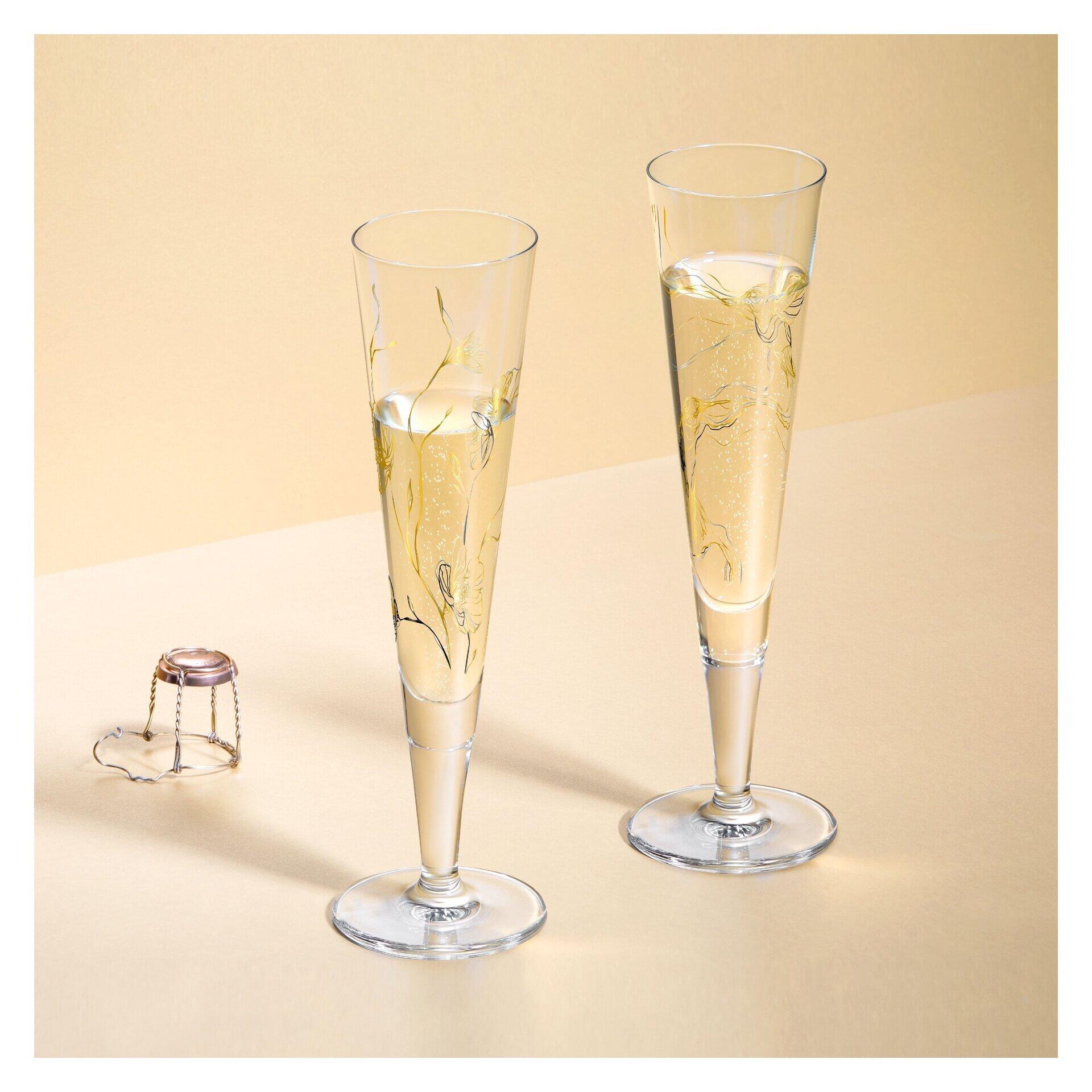 Zwei Champagnergläser mit schlankem Stiel und trichterförmiger Öffnung, gefüllt mit Champagner, auf einem Untergrund, aufgenommen aus leicht erhöhter Perspektive.