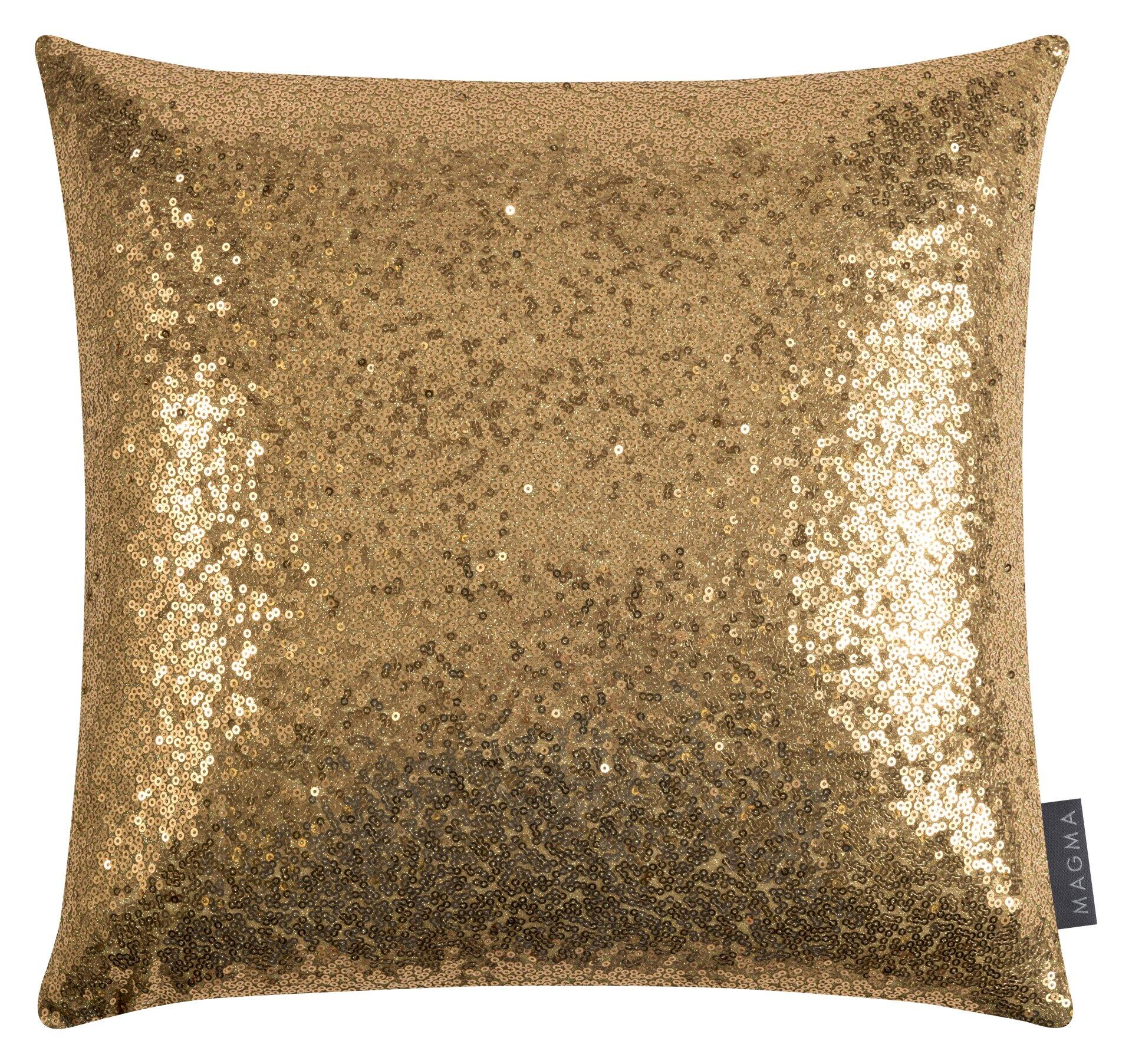 Kissenhülle Glitter: Nahaufnahme eines goldenen Kissens mit dicht angeordneten, reflektierenden Pailletten und einem "MAGMA"-Etikett am unteren Rand.