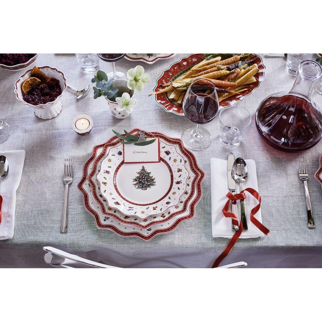 Weißer Frühstücksteller Toy's Delight mit weihnachtlichem Dekor aus roten Ästen, grünen Blättern und Beeren auf festlich gedeckter Tafel.