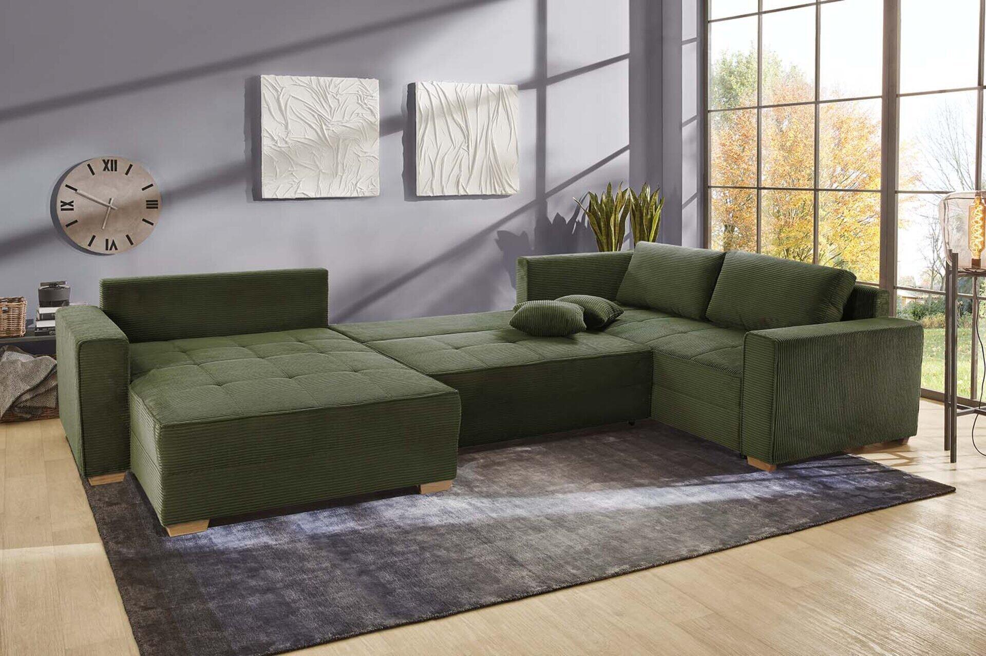 Wohnlandschaft Brixen mit dunkelgrünem Cordstoff, Eichenholzfüßen und einer links- oder rechts montierbaren Chaiselongue, dargestellt in einer frontalen Perspektive.