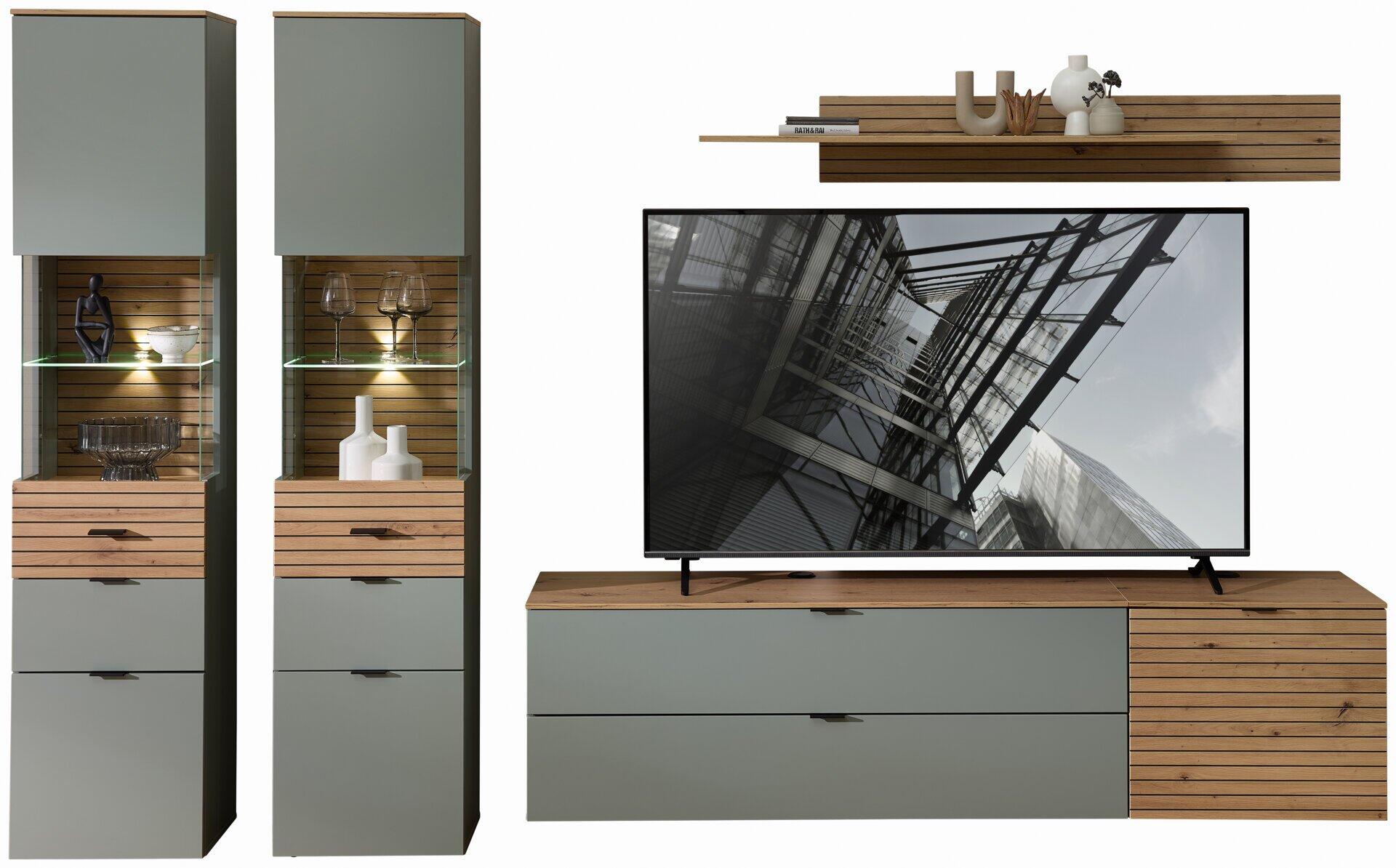 TV-/Wohnlösung Ina mit niedriger TV-Konsole, Vitrine mit Glastüren und Wandregal, die die Kombination aus Grau, Holzoptik und LED-Beleuchtung zeigt.